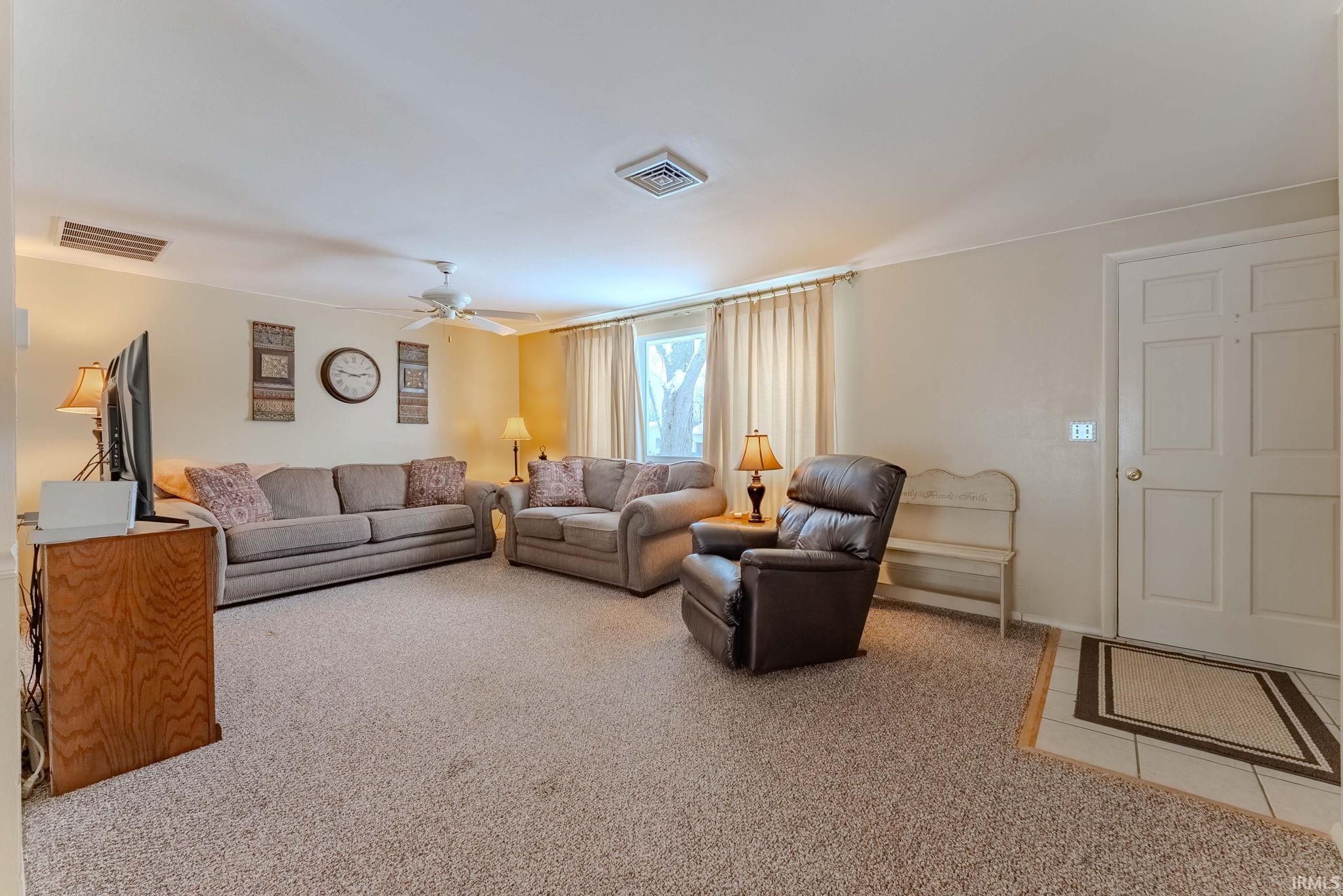 Living room featuring carpet and ceiling fan