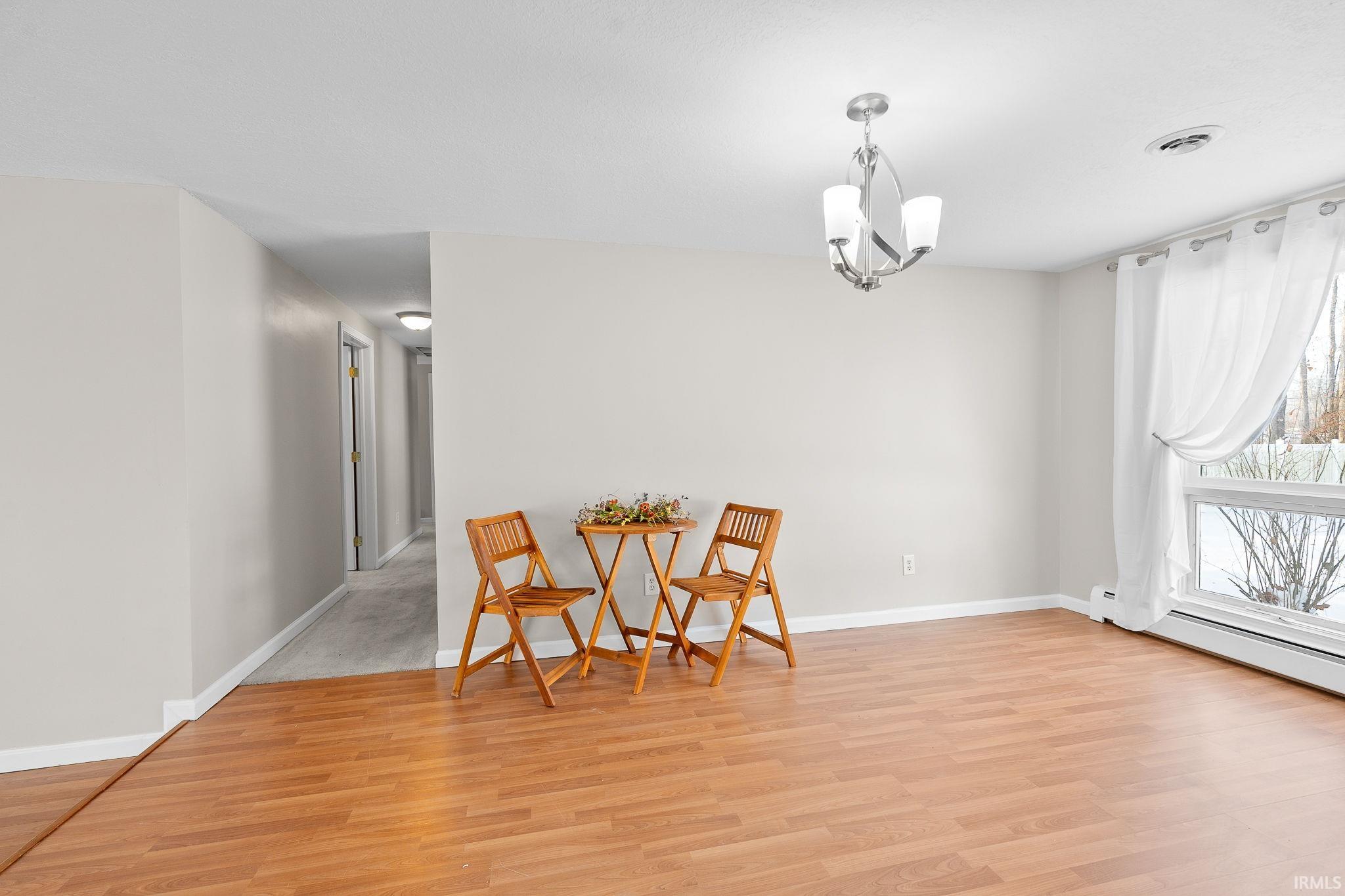Living area with light wood-style floors and a chandelier