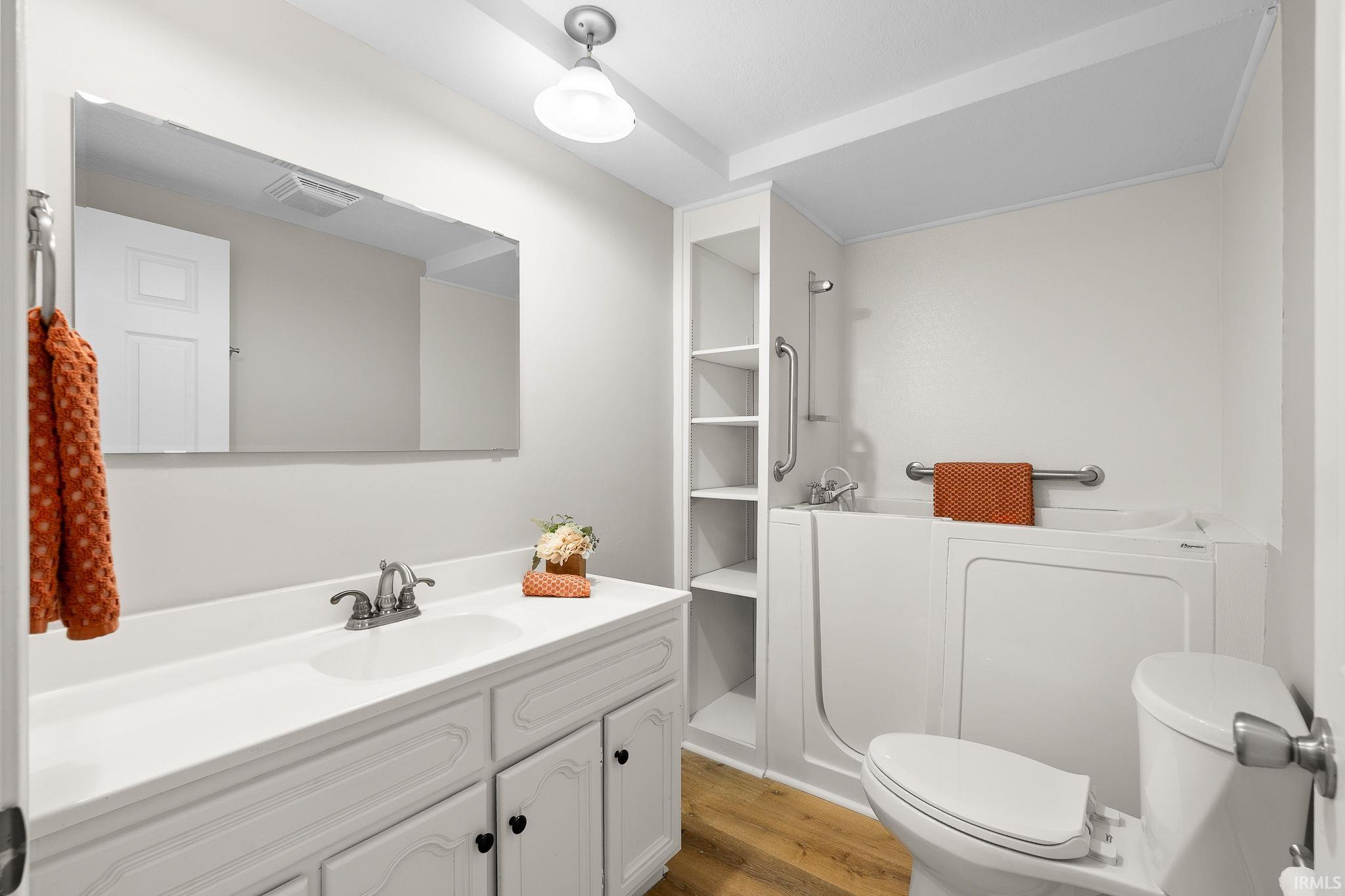 Full bathroom featuring vanity, light wood-style floors, a bath, and a shower
