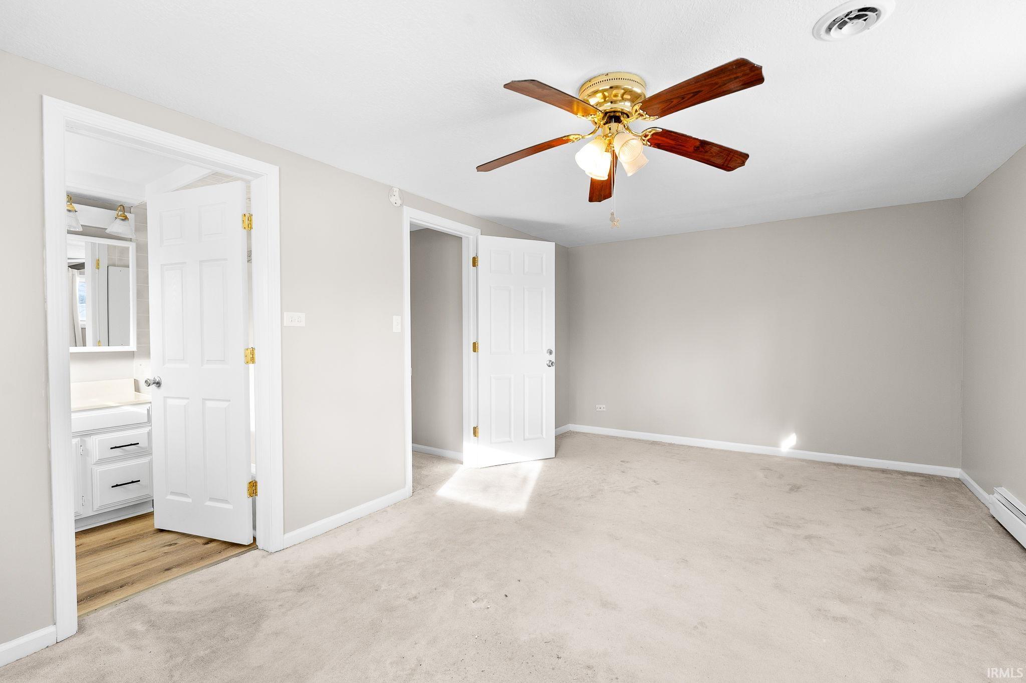 Unfurnished bedroom featuring light carpet and ceiling fan