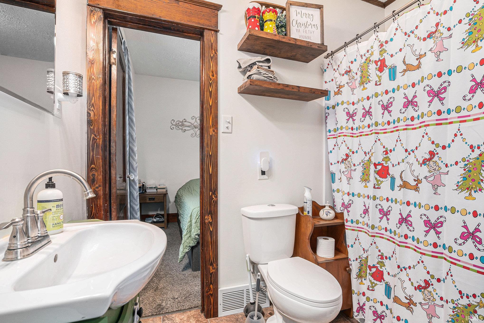 Ensuite bathroom featuring curtained shower and a textured ceiling