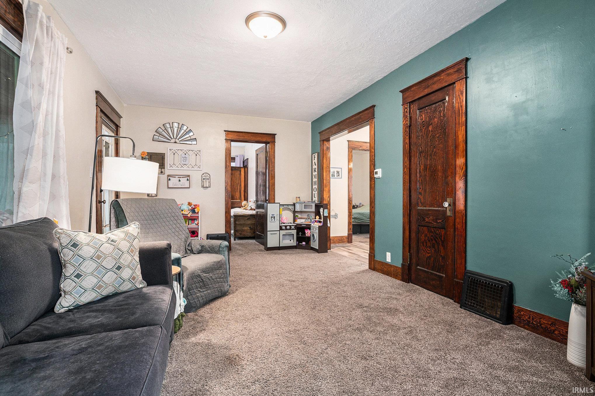 Living room featuring carpet floors and a textured ceiling