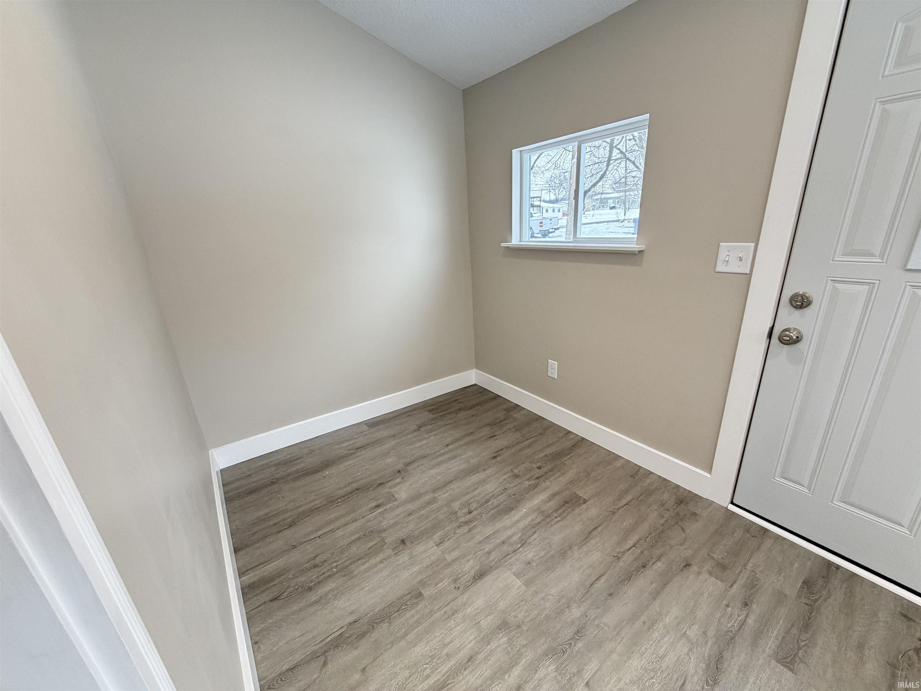 Unfurnished room featuring light wood-style flooring and lofted ceiling