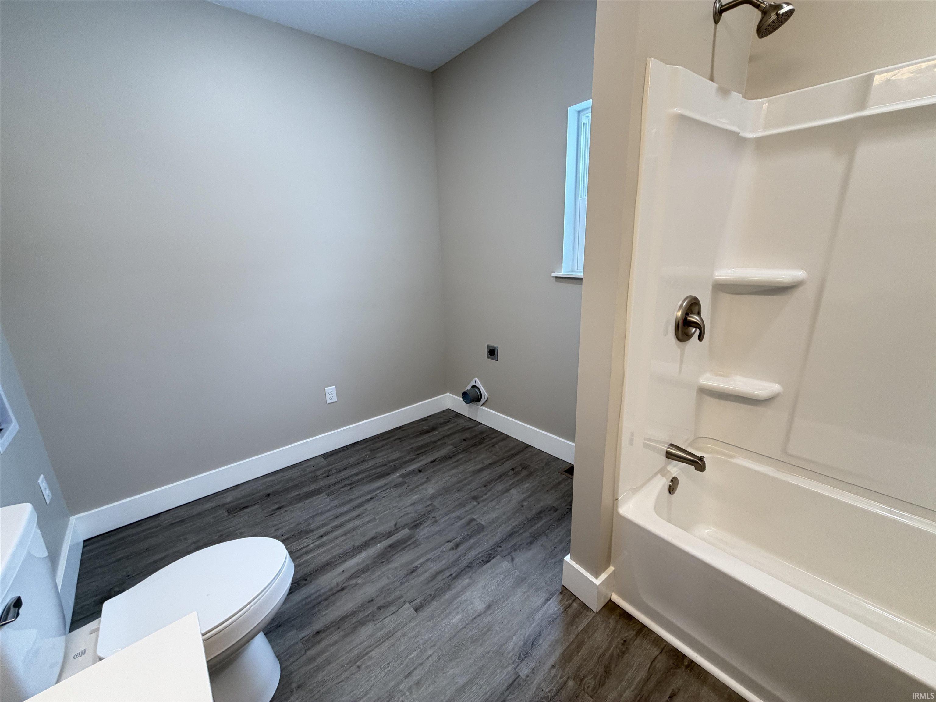 Full bath featuring bathtub / shower combination and dark wood-type flooring