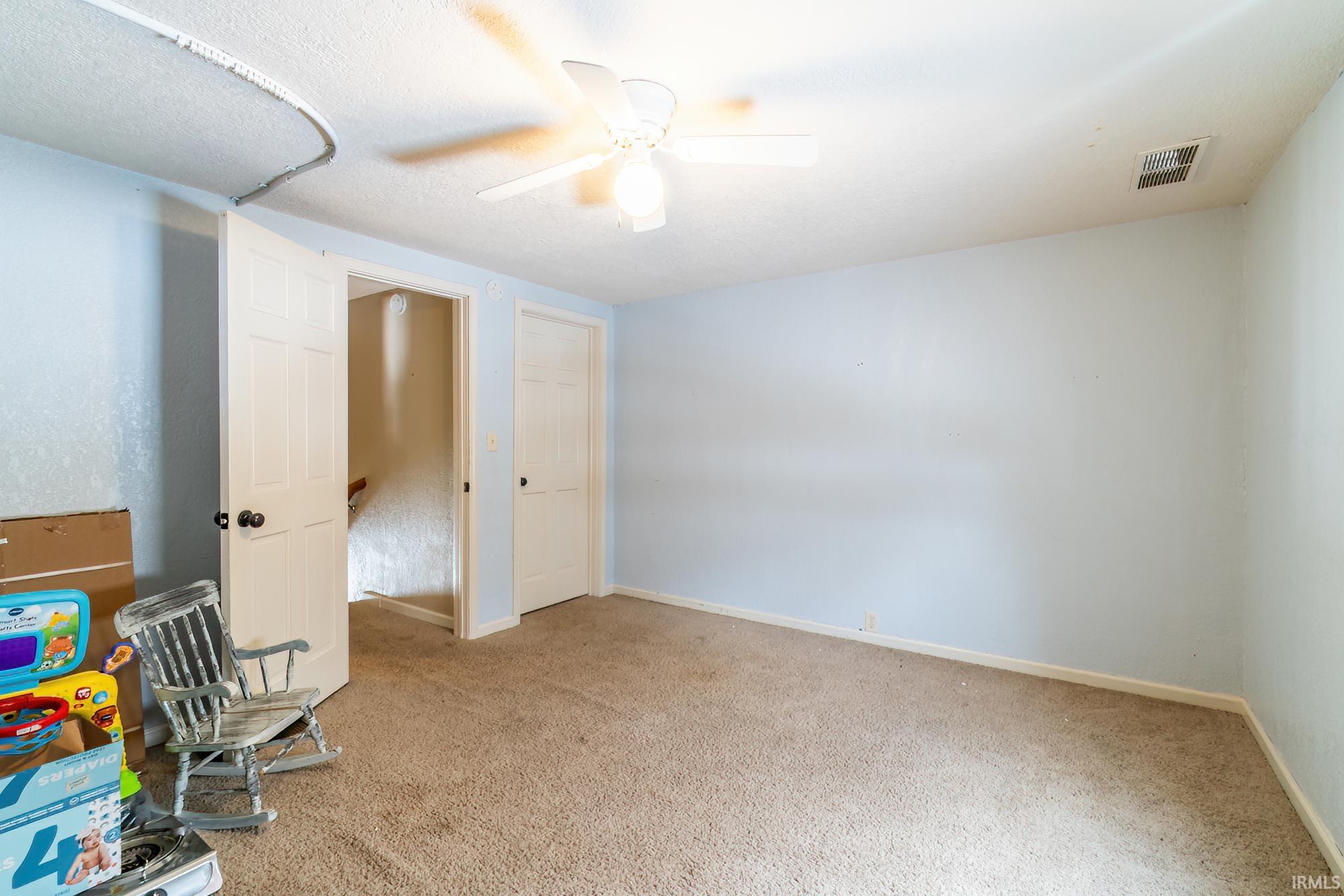Unfurnished room featuring light colored carpet and a ceiling fan
