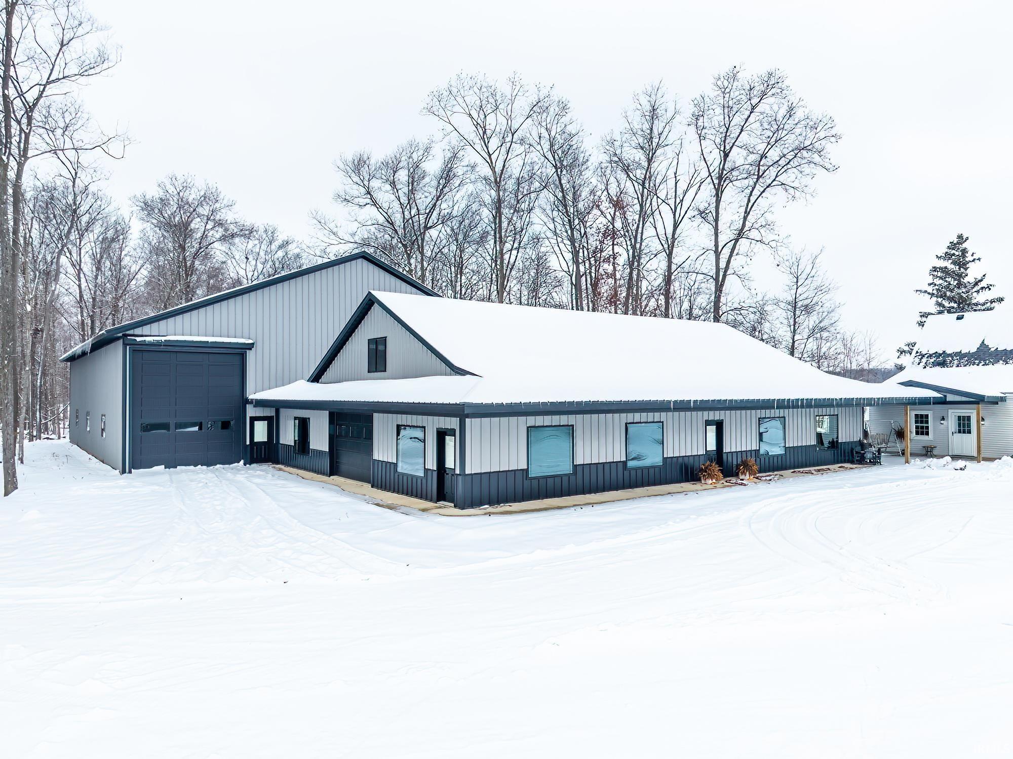 Snow covered property featuring a garage