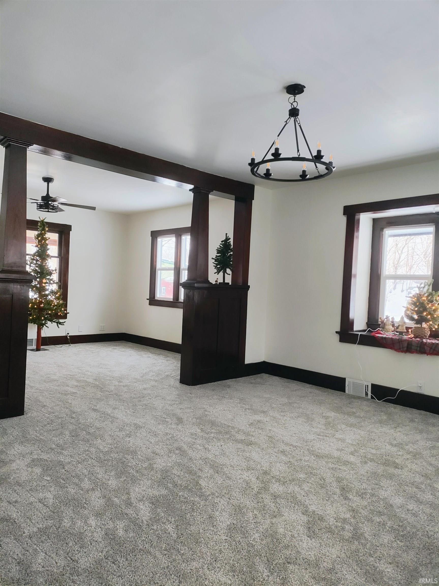 Unfurnished living room with light carpet and a ceiling fan