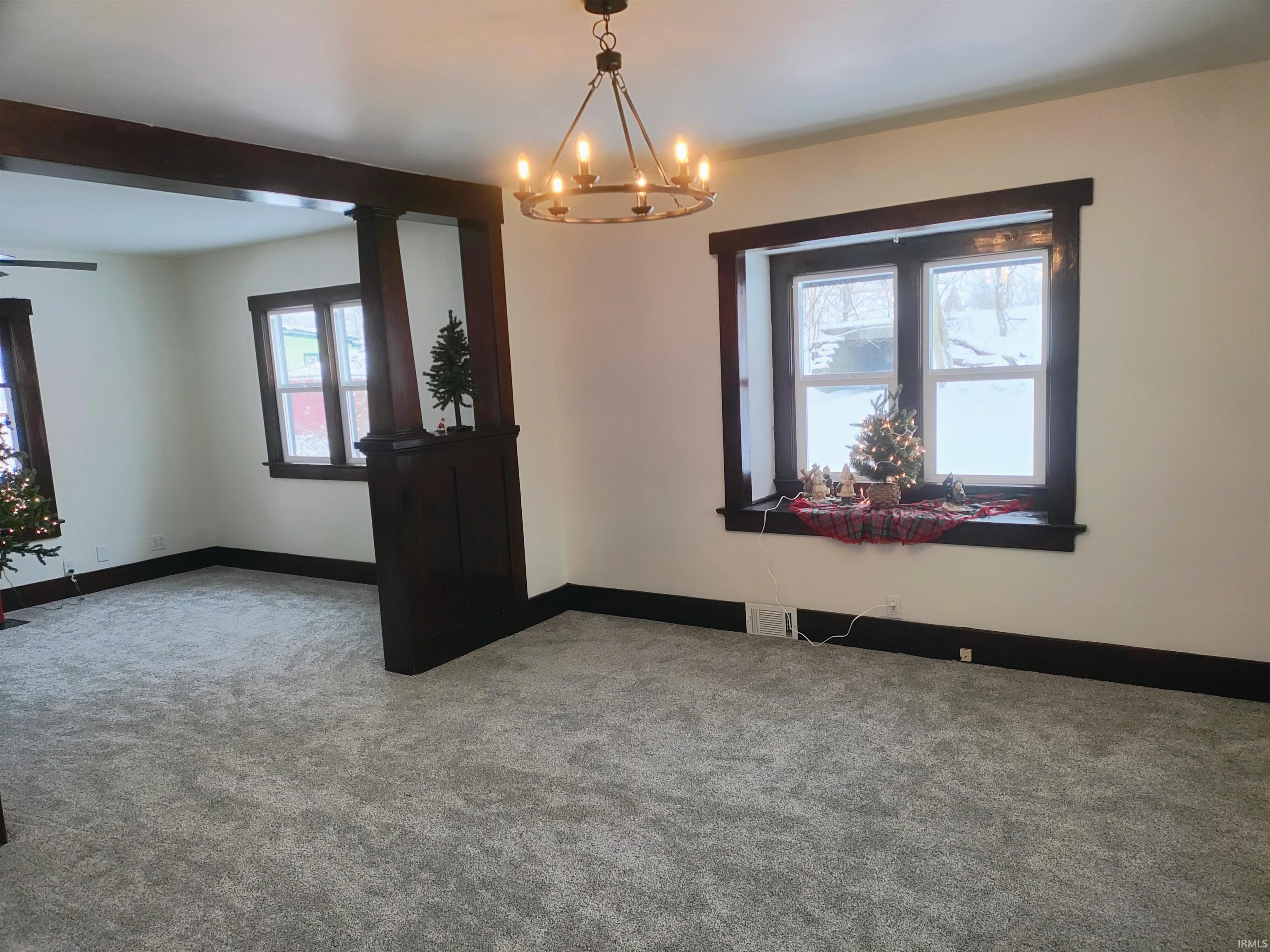 Spare room with carpet flooring and a chandelier