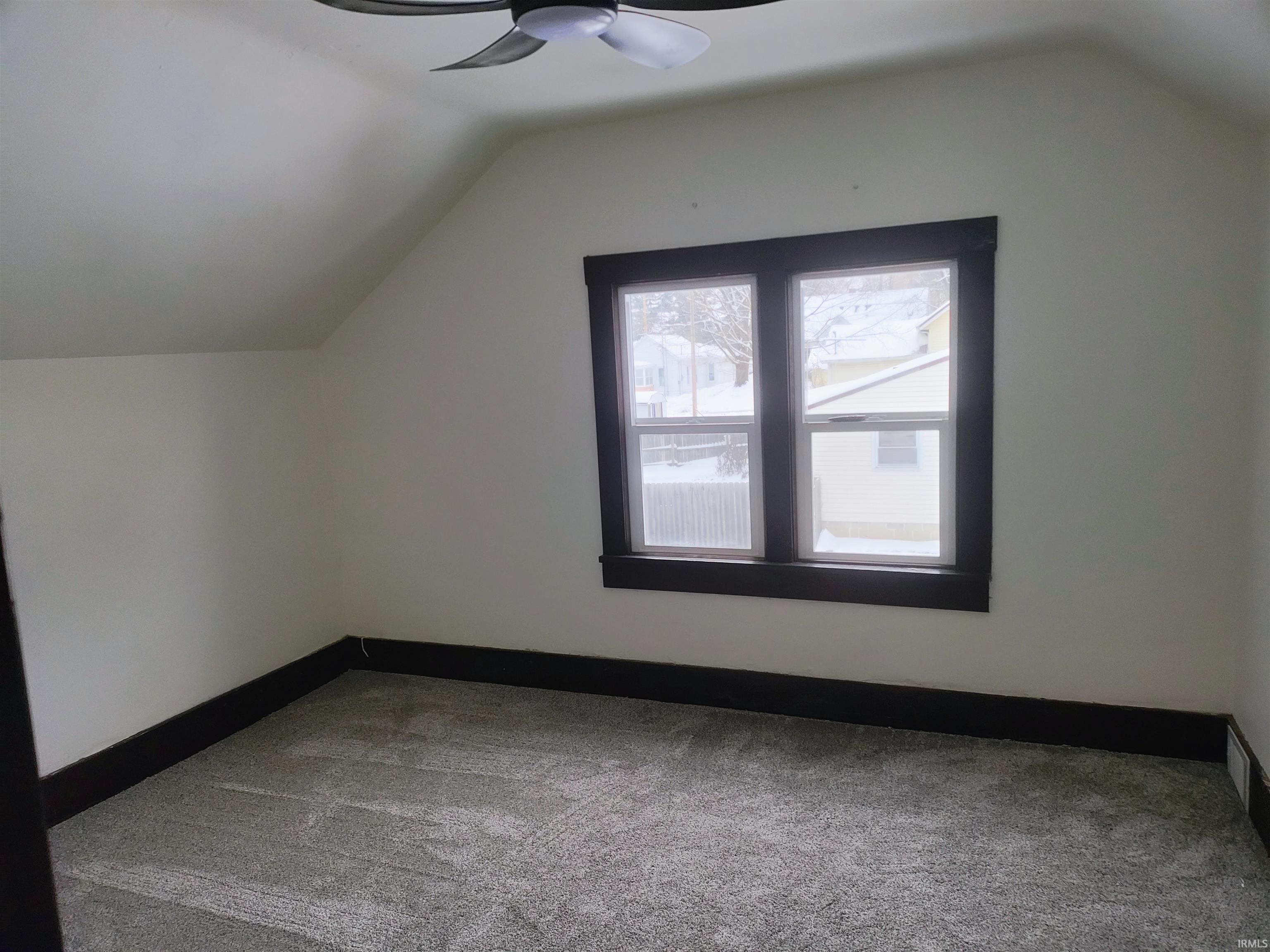 Bonus room featuring carpet flooring, lofted ceiling, and a ceiling fan