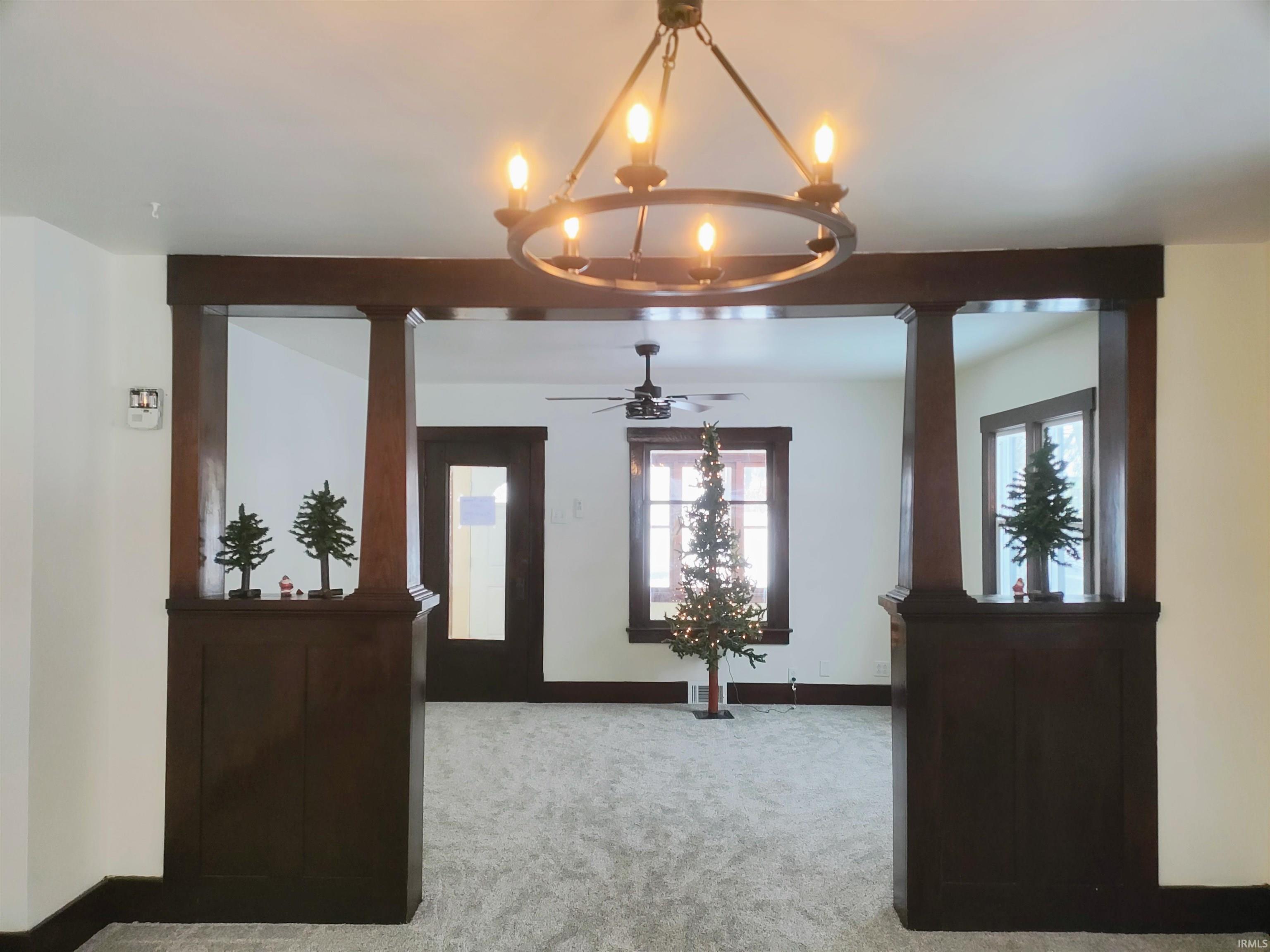 Entryway with carpet, a chandelier, and a ceiling fan