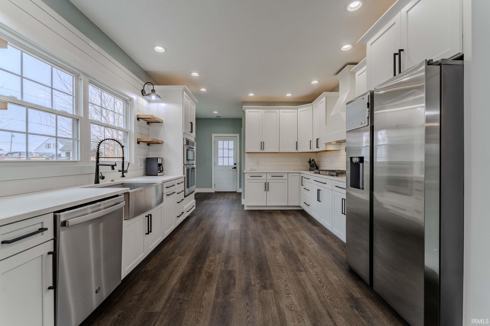 Kitchen featuring stainless steel appliances, white cabinets, recessed lighting, dark wood-style floors, and tasteful backsplash