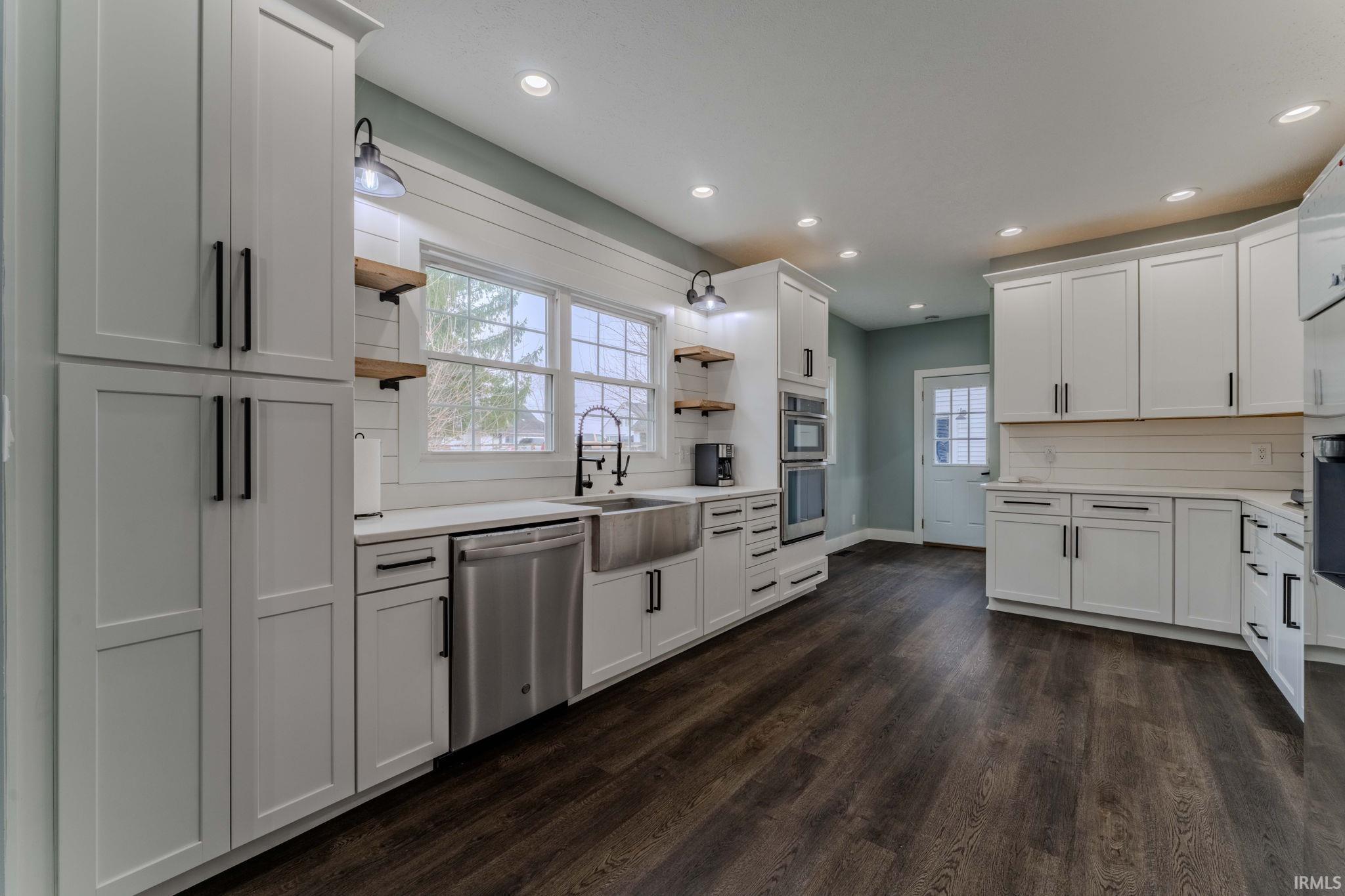 Kitchen featuring open shelves, decorative backsplash, white cabinetry, stainless steel appliances, and recessed lighting