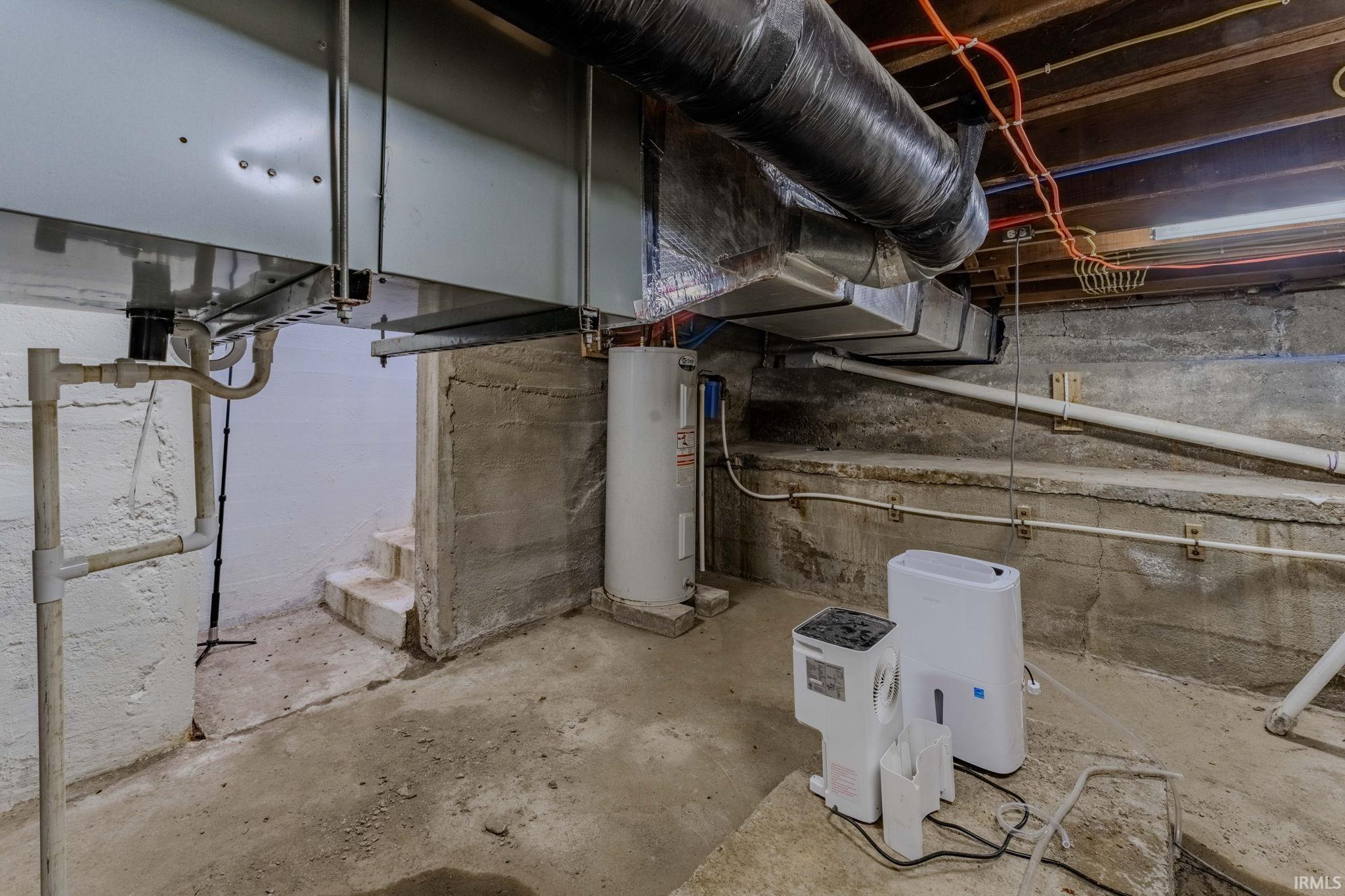 Unfinished basement featuring water heater