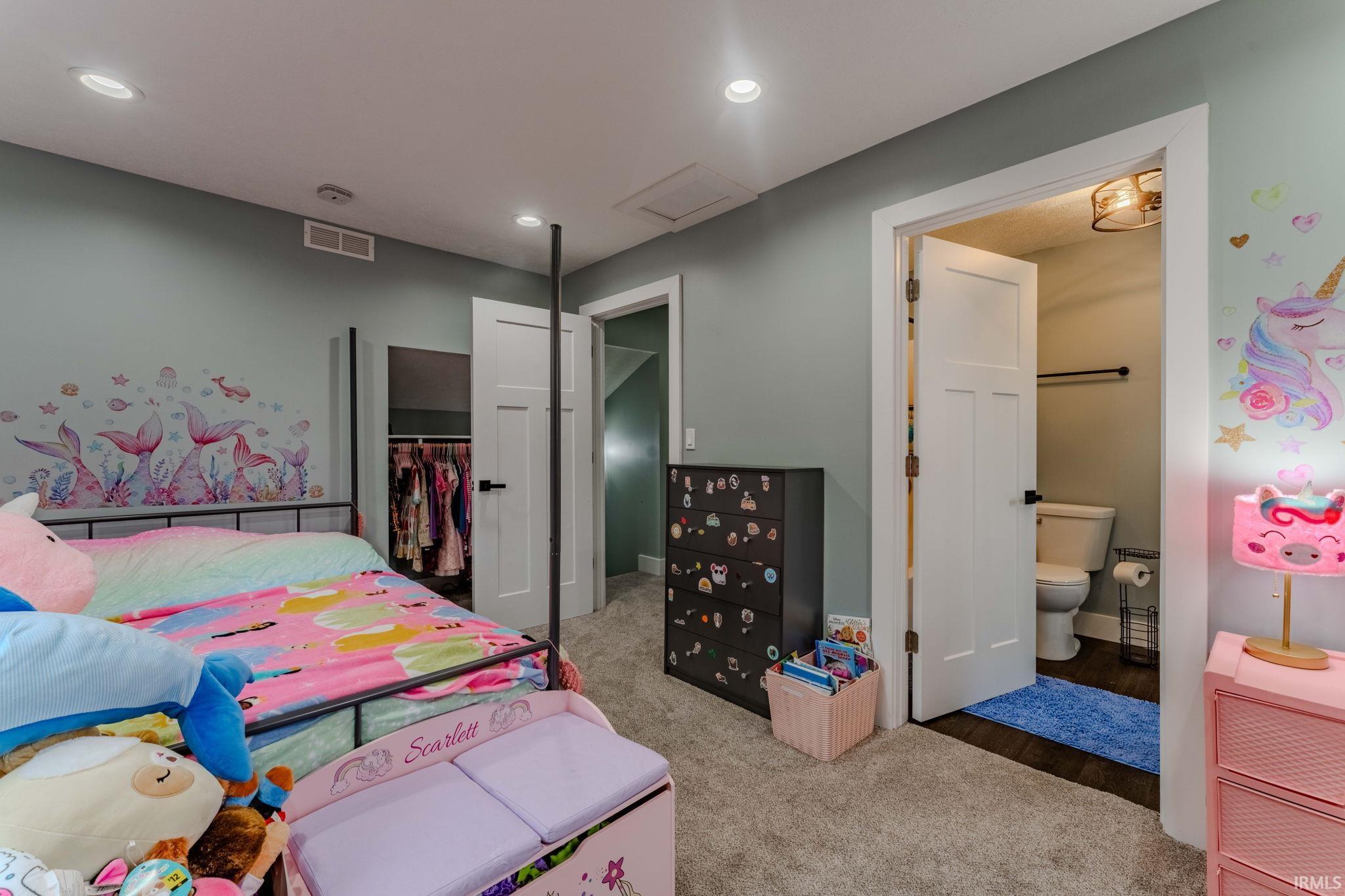 Bedroom featuring a closet, recessed lighting, light carpet, attic access, and ensuite bath