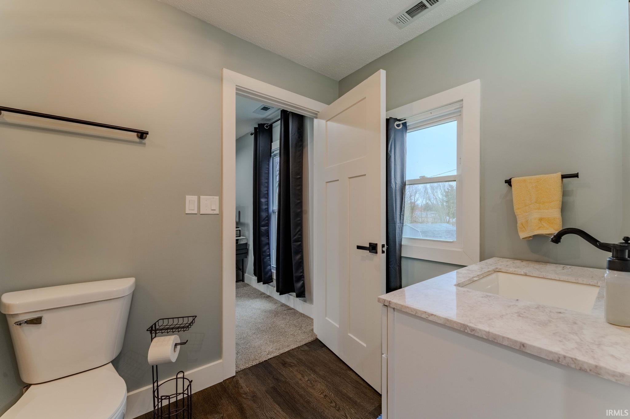 Bathroom with vanity and dark wood-style flooring