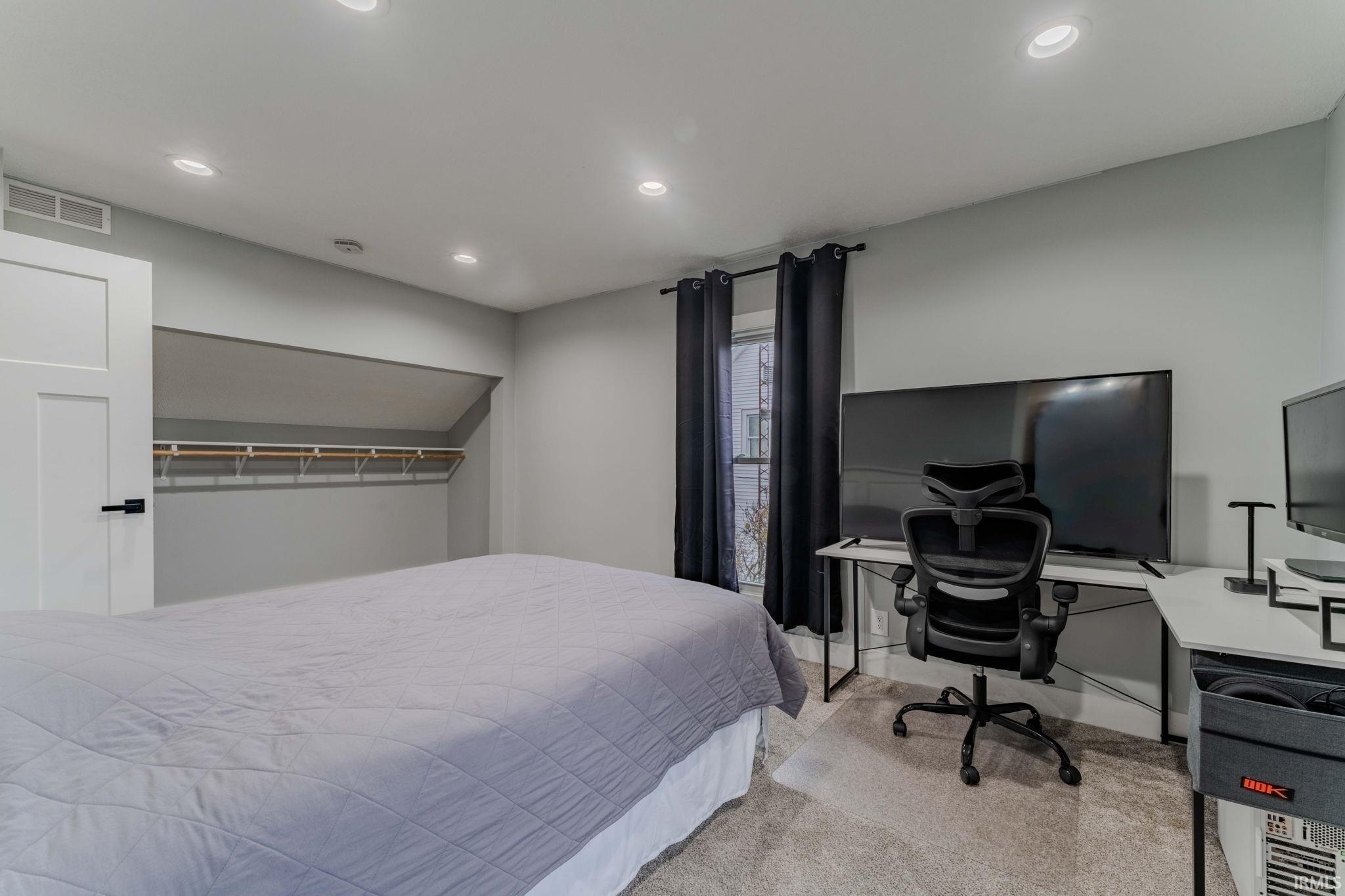Bedroom with recessed lighting, a desk, and light colored carpet