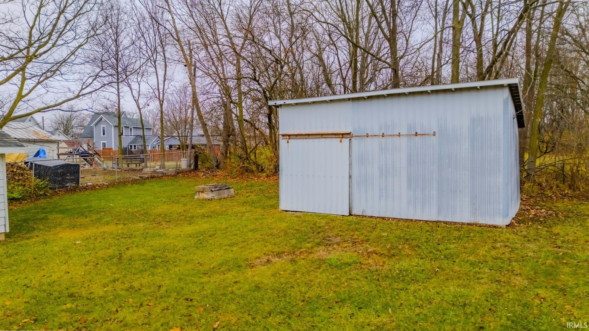 View of yard featuring a fire pit and an outbuilding
