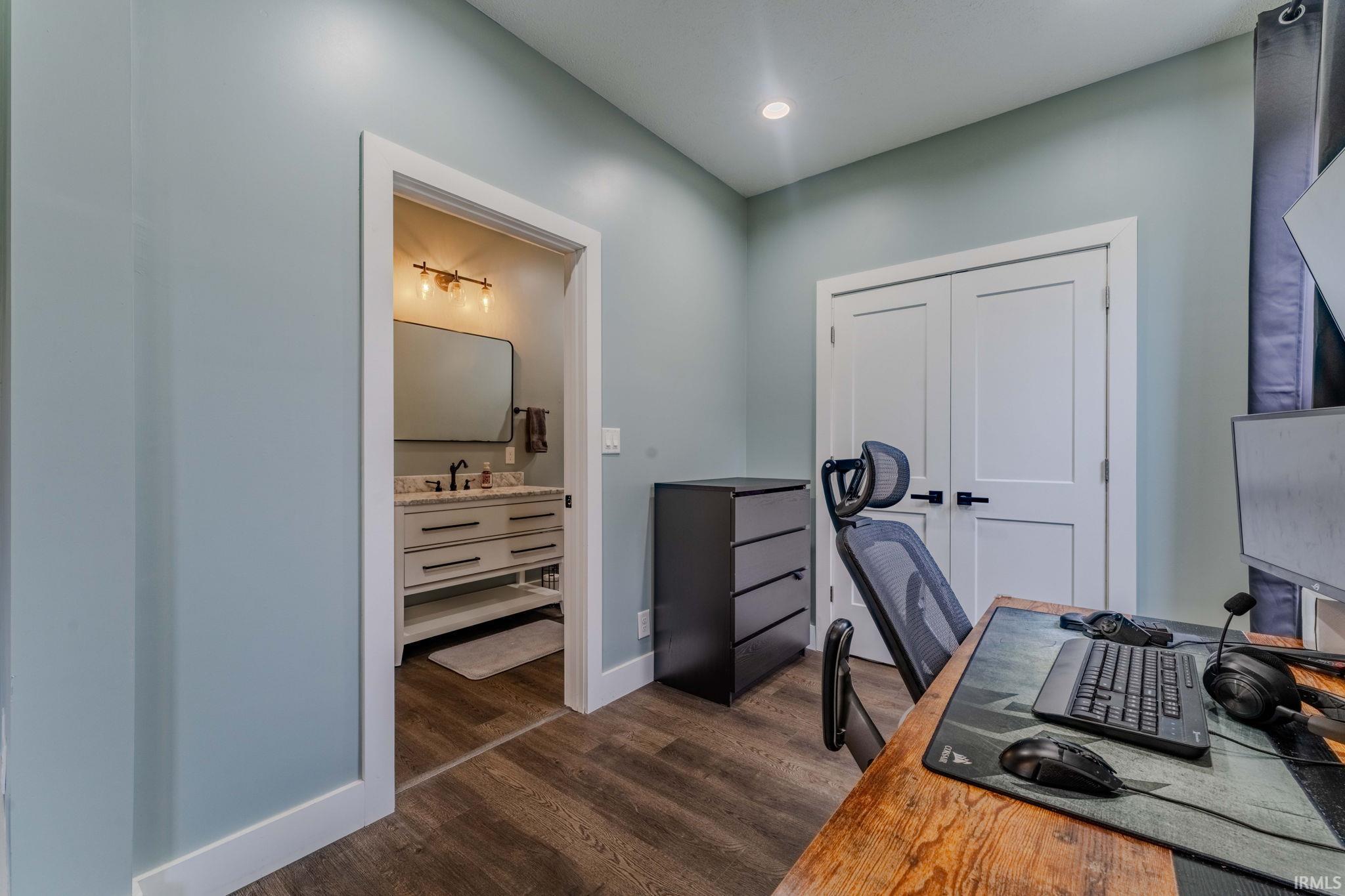 Office area featuring dark wood-style floors and baseboards