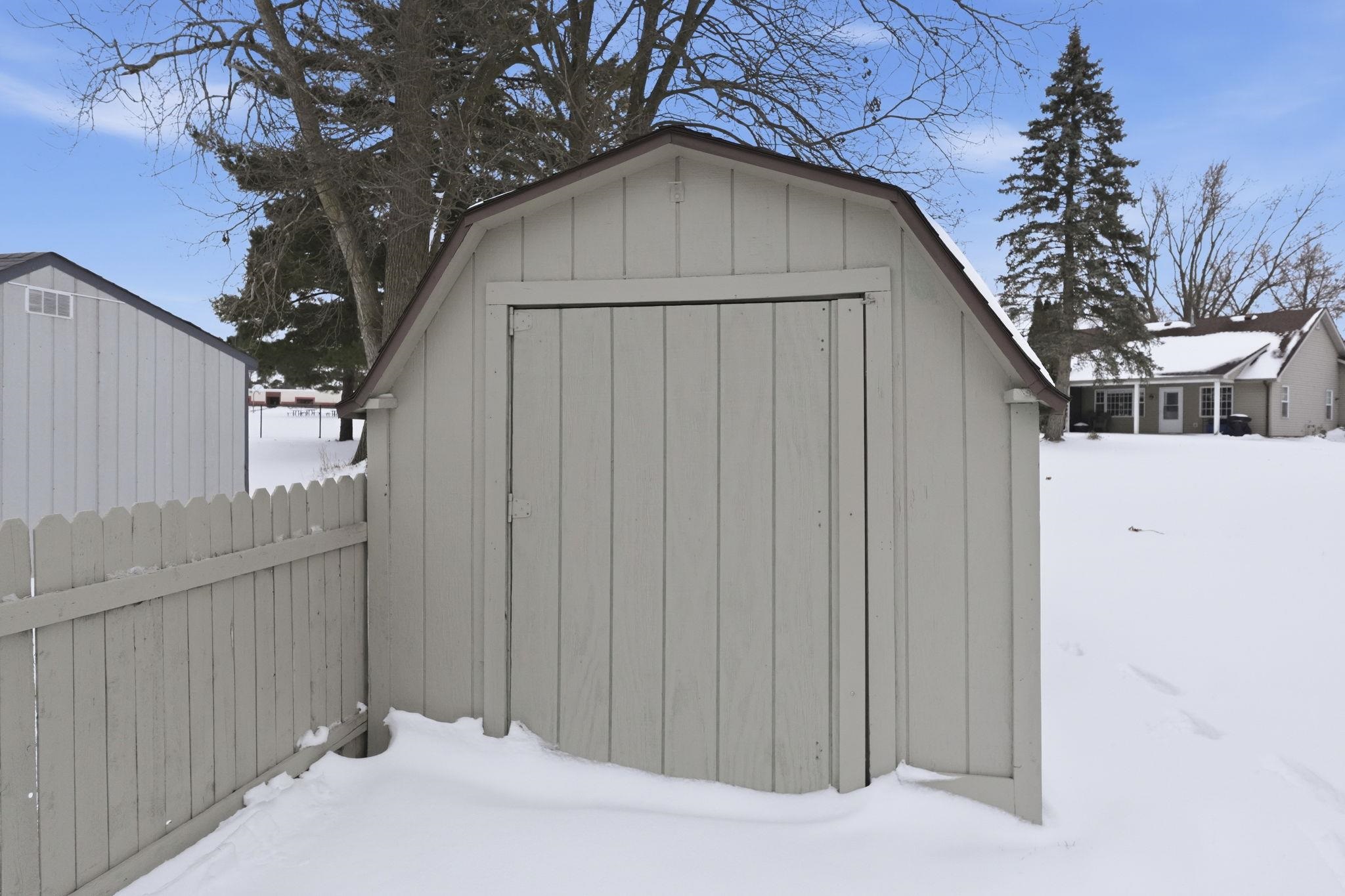 Snow covered structure with a shed