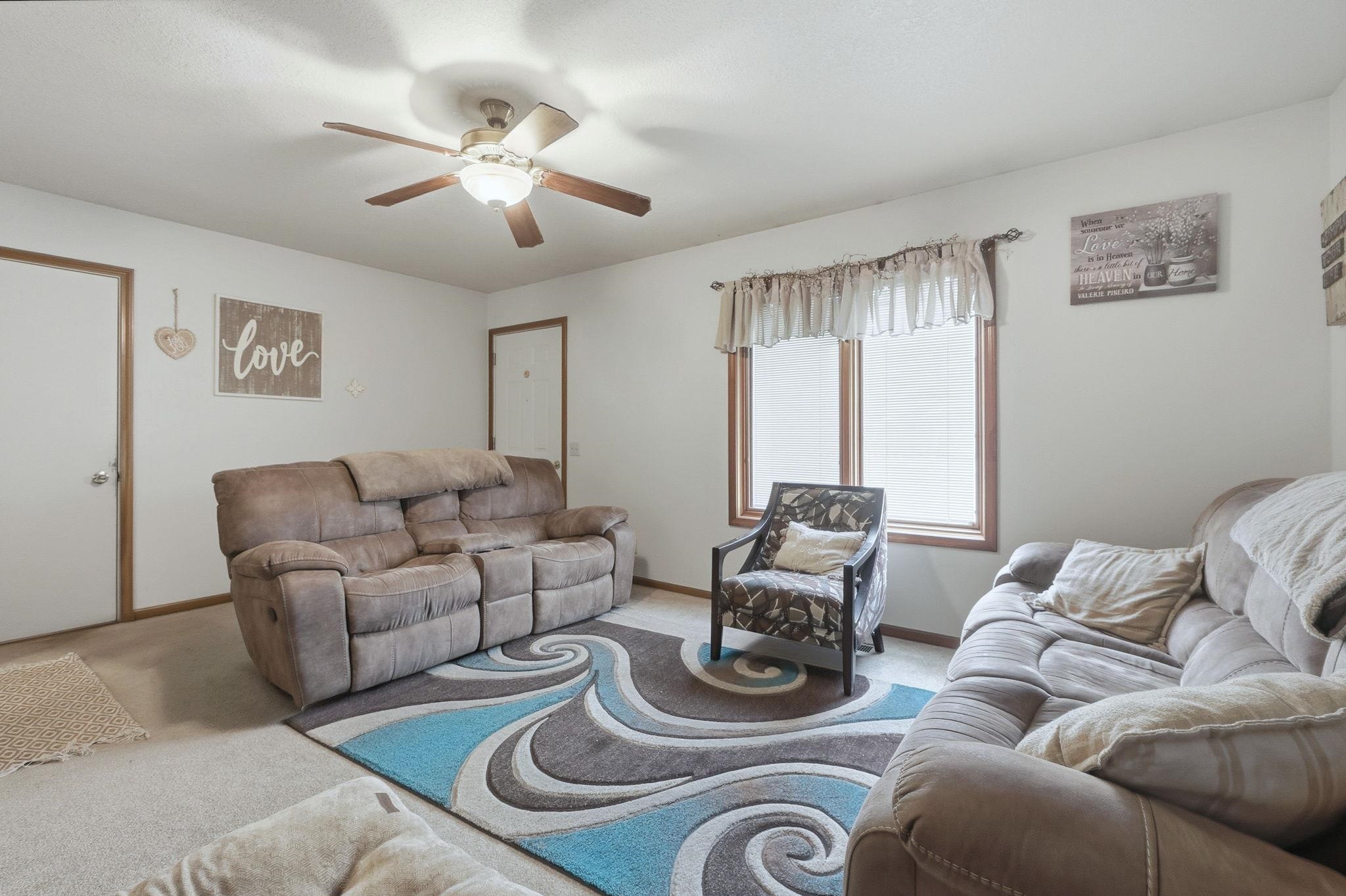 Living area with carpet and ceiling fan