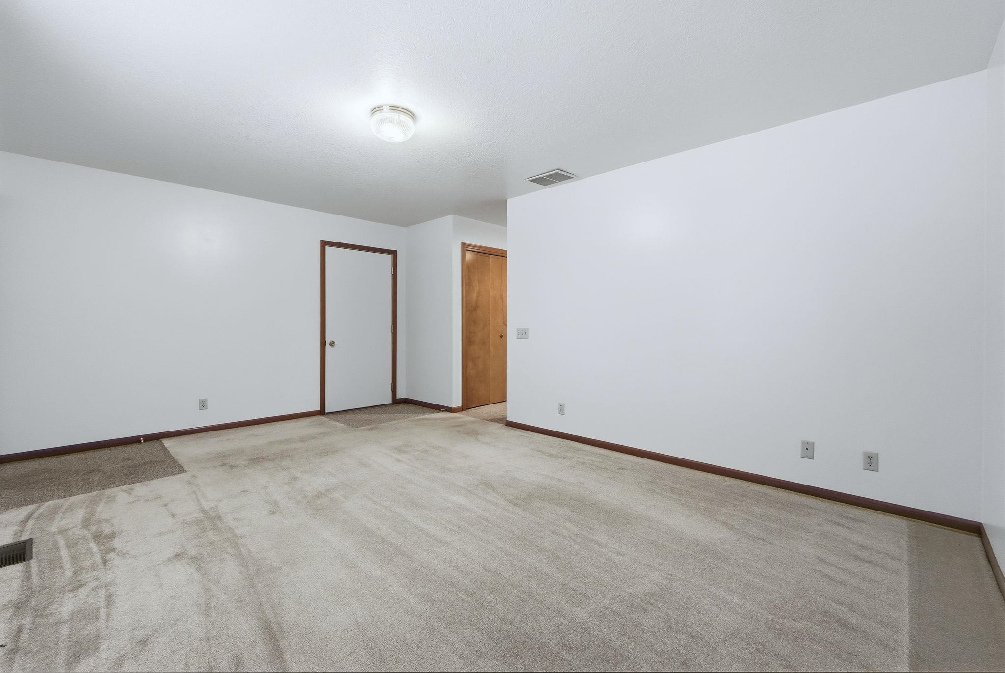 Spare room with carpet and baseboards