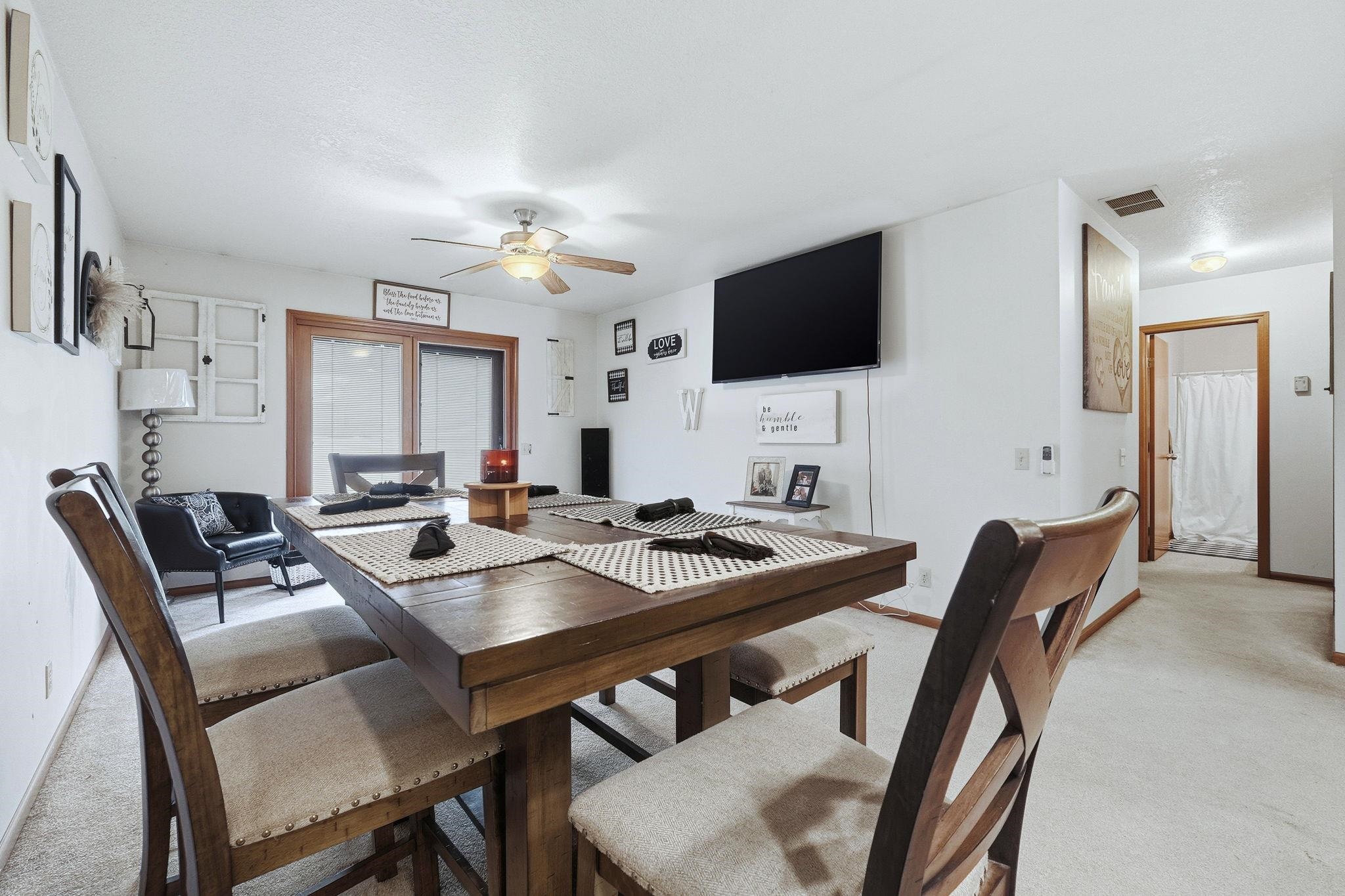 Dining room with light carpet and ceiling fan