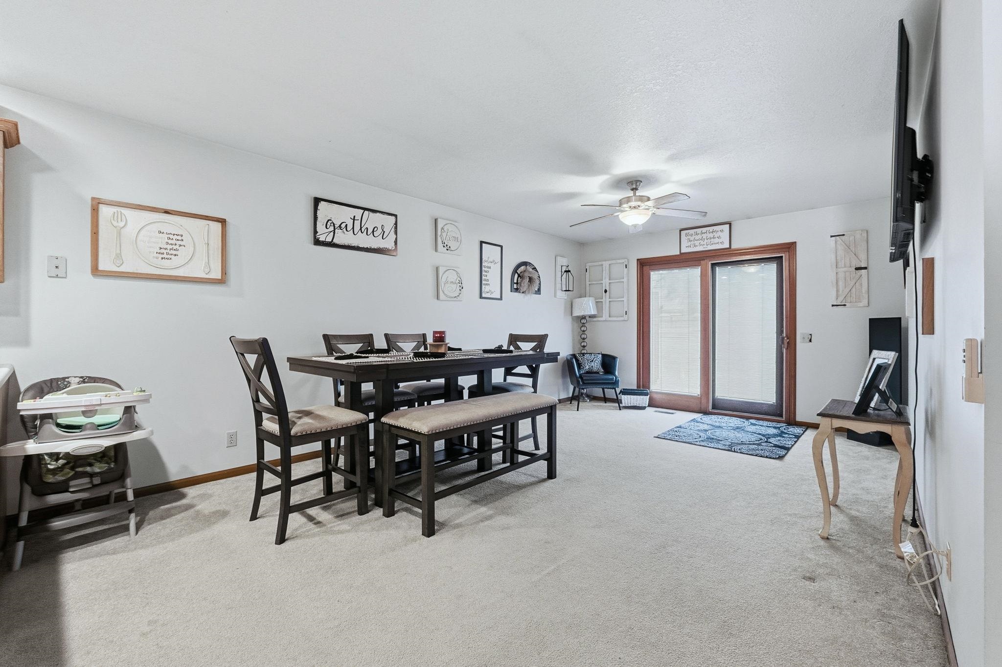 Dining space featuring light colored carpet and a ceiling fan