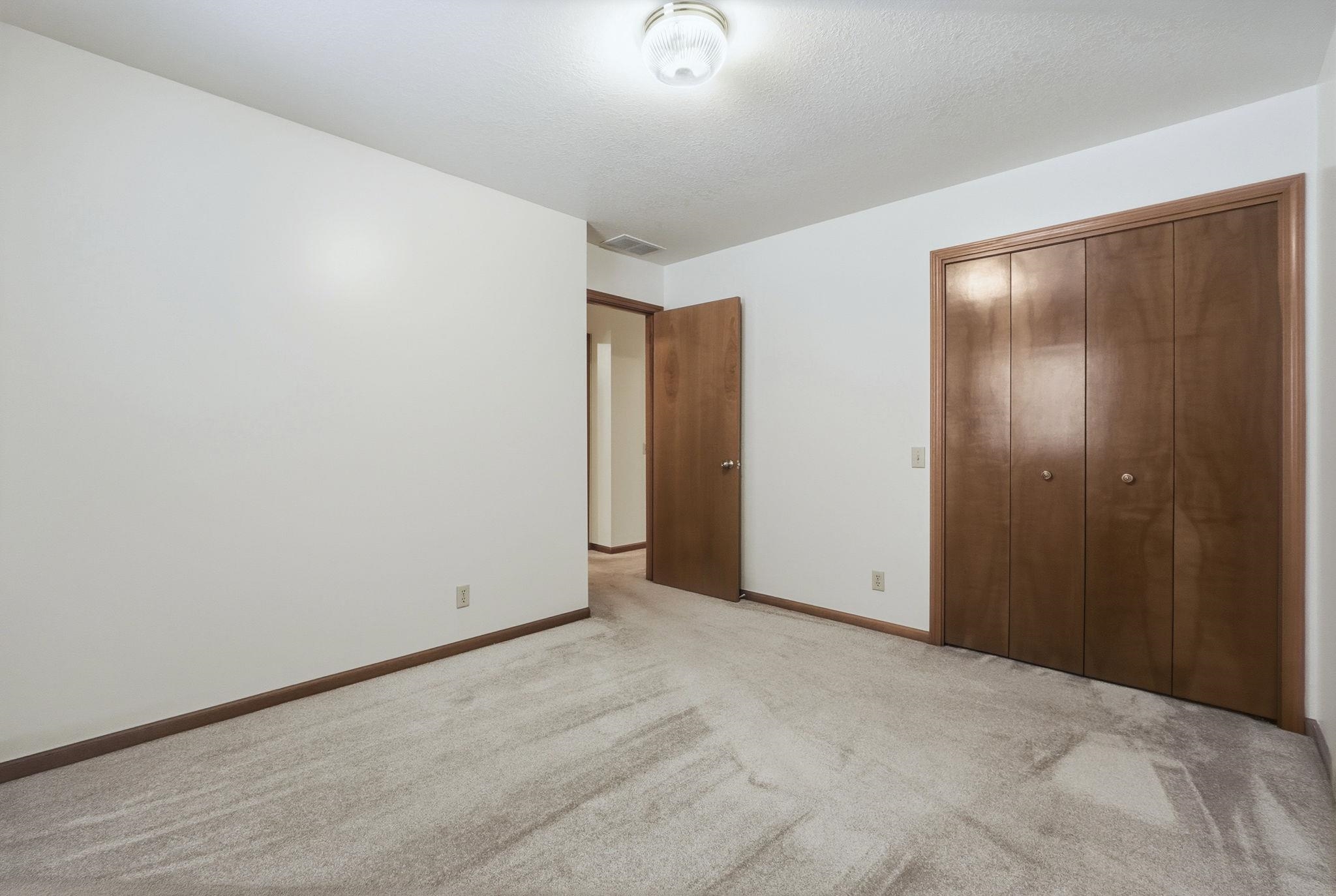 Unfurnished bedroom featuring a closet and light carpet