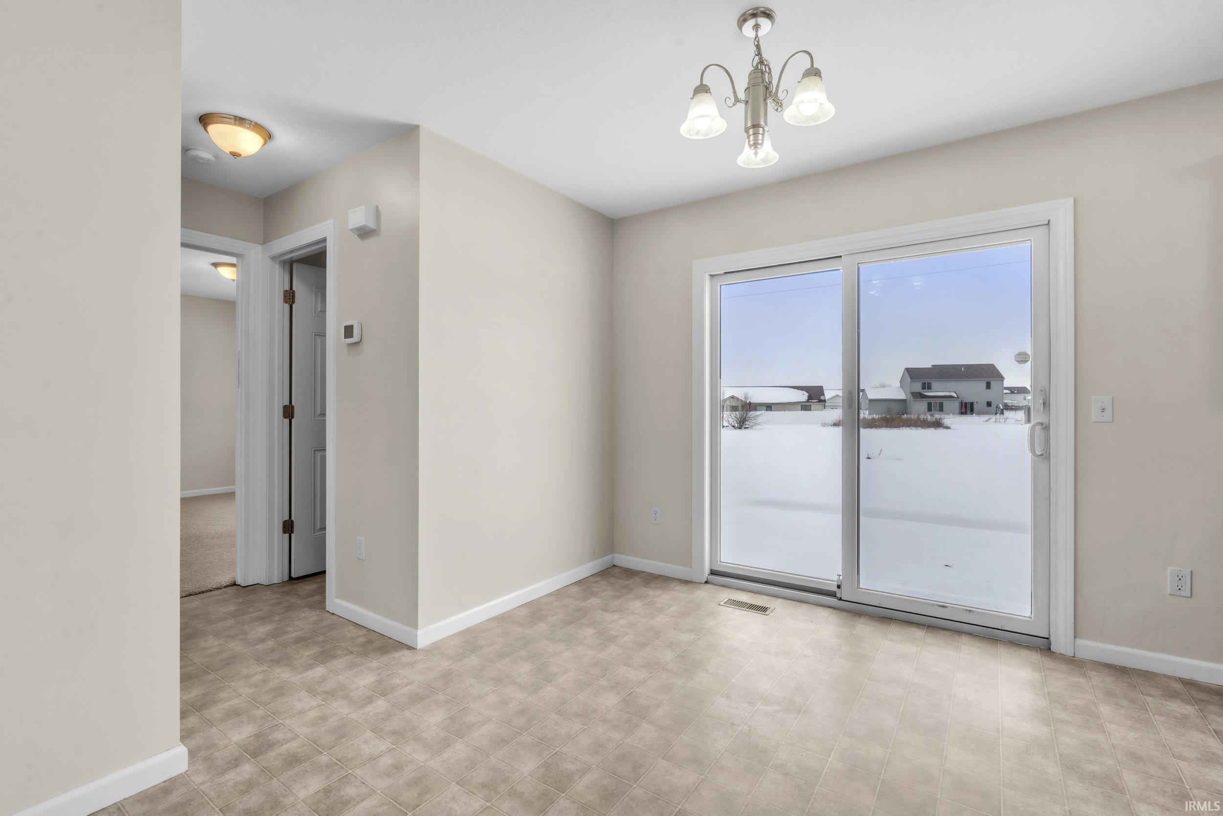 Empty room with a chandelier and light floors