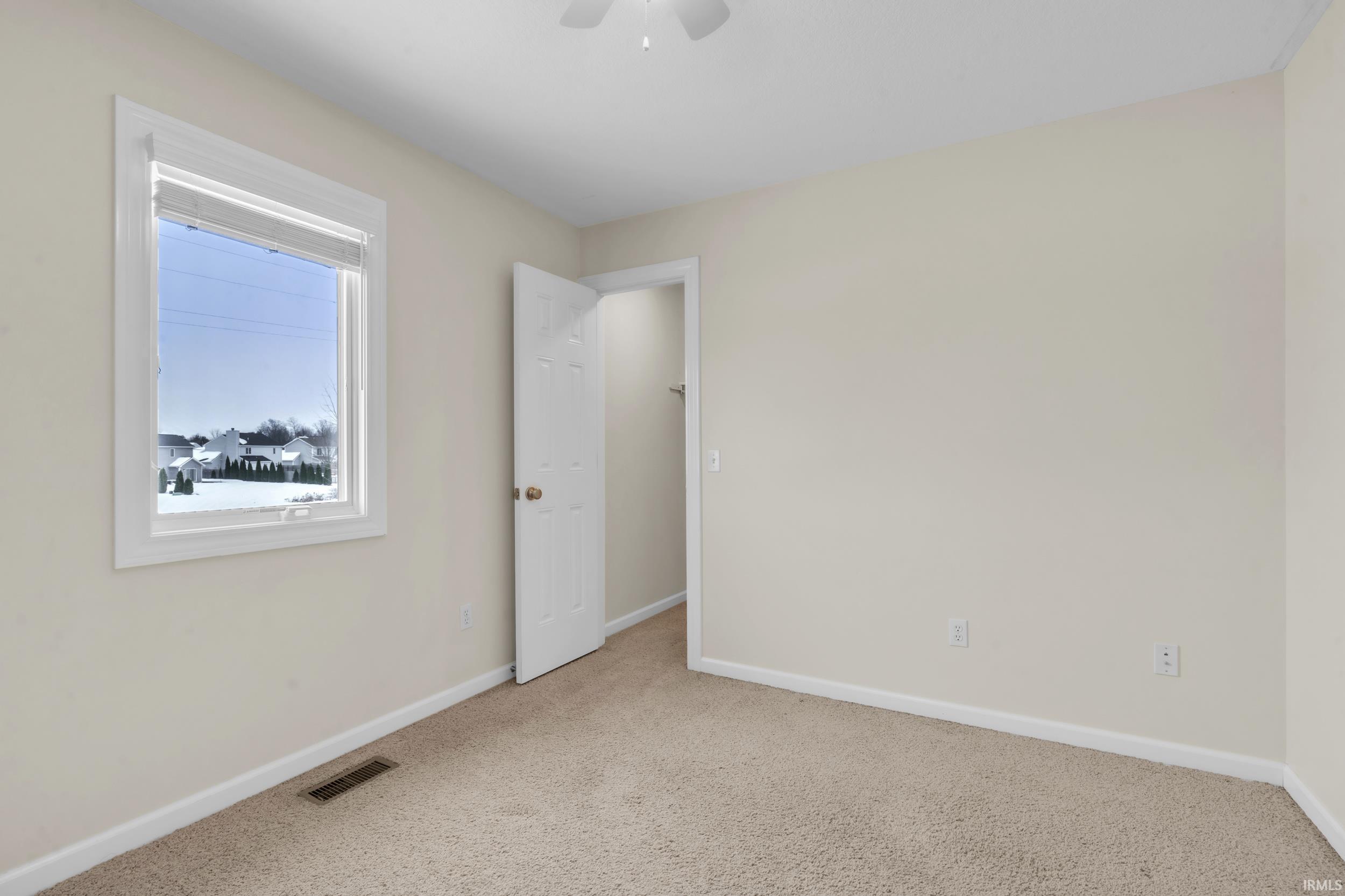 Unfurnished room featuring carpet floors and ceiling fan
