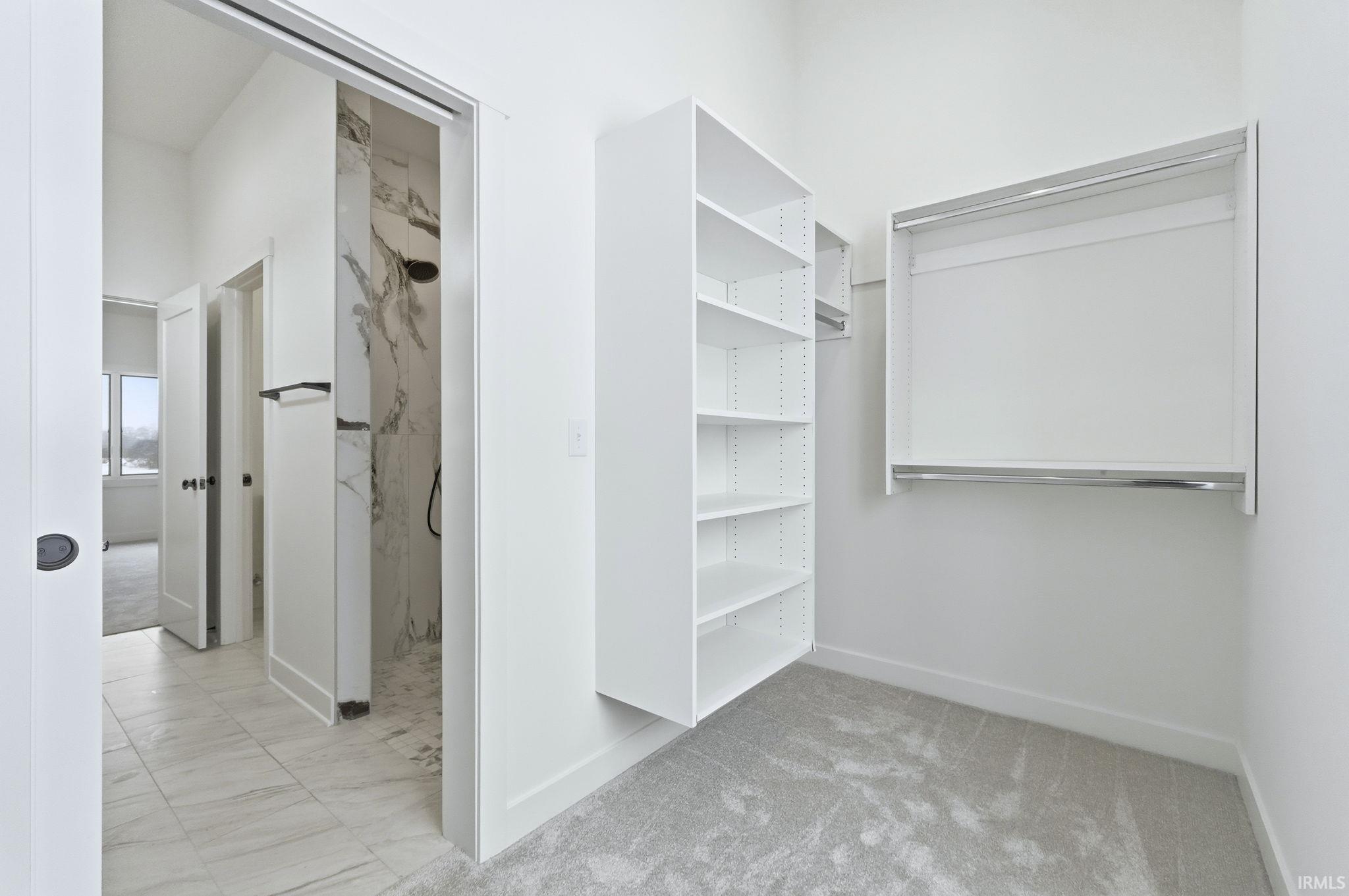 Spacious closet with light marble finish floors