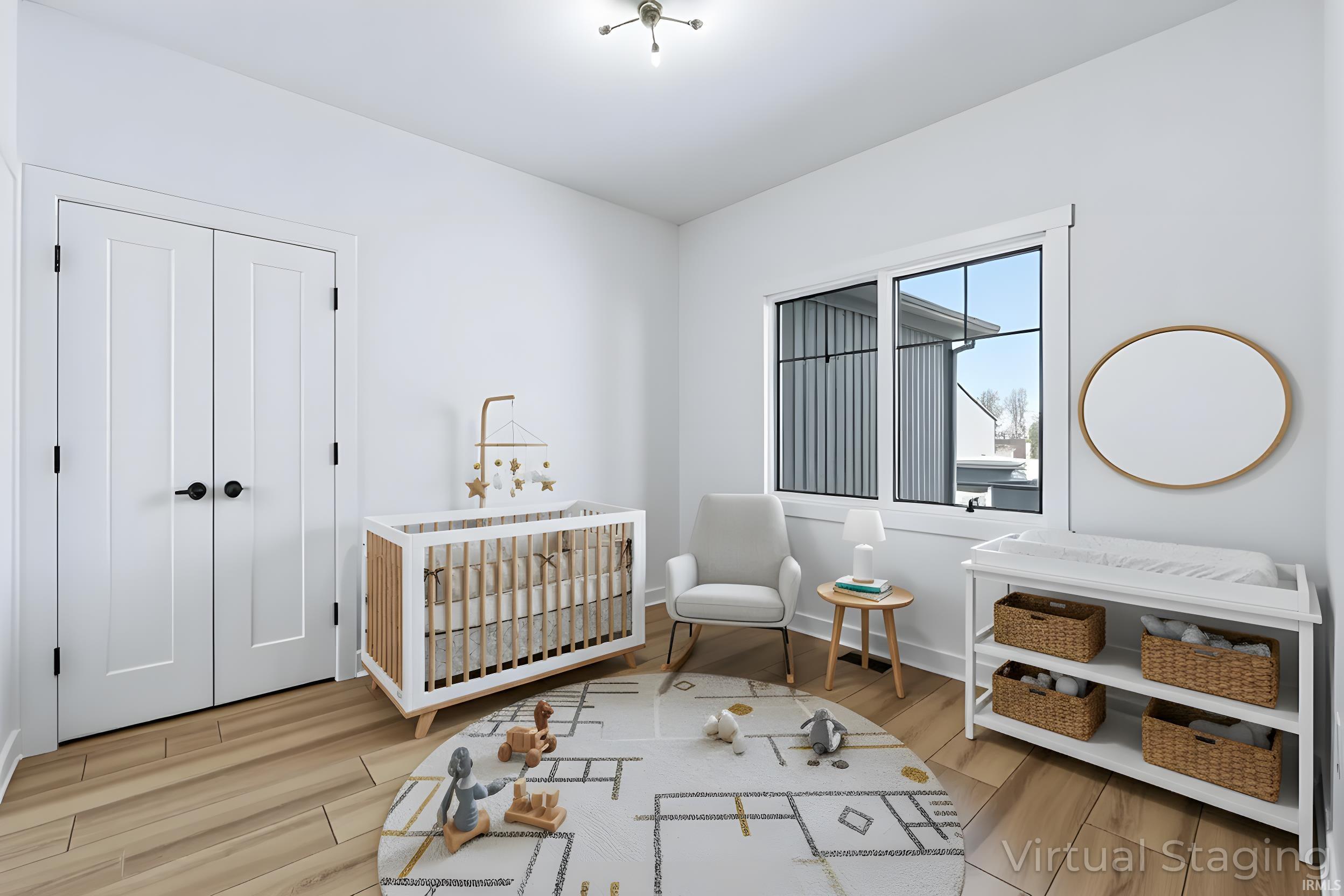 Bedroom with a crib, light wood-style flooring, and a closet