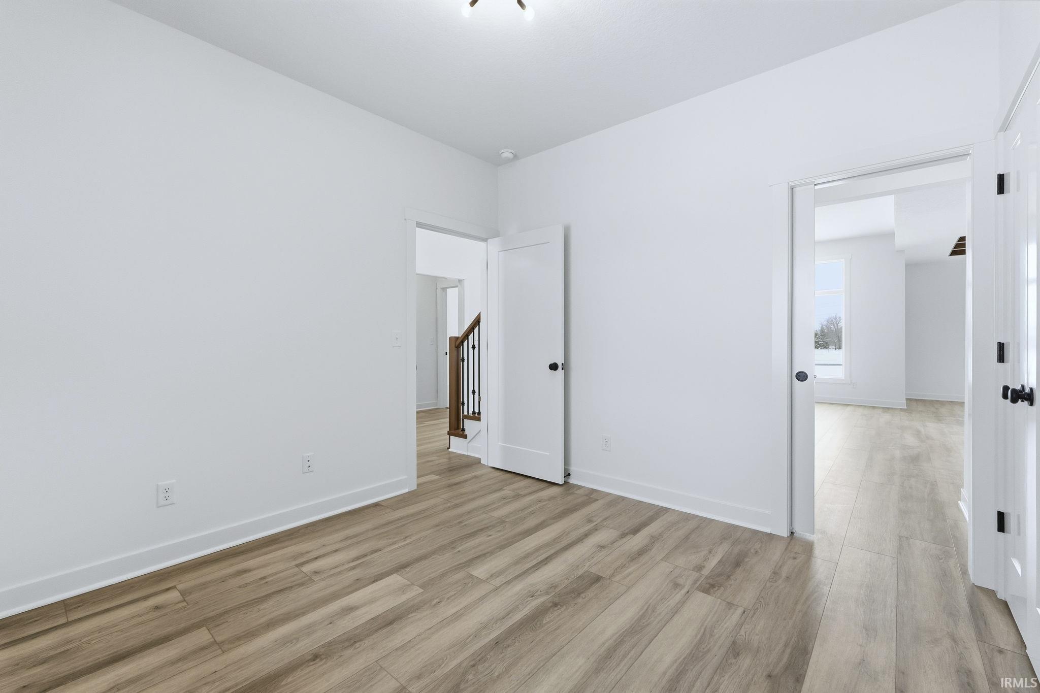 Unfurnished room featuring light wood finished floors and baseboards