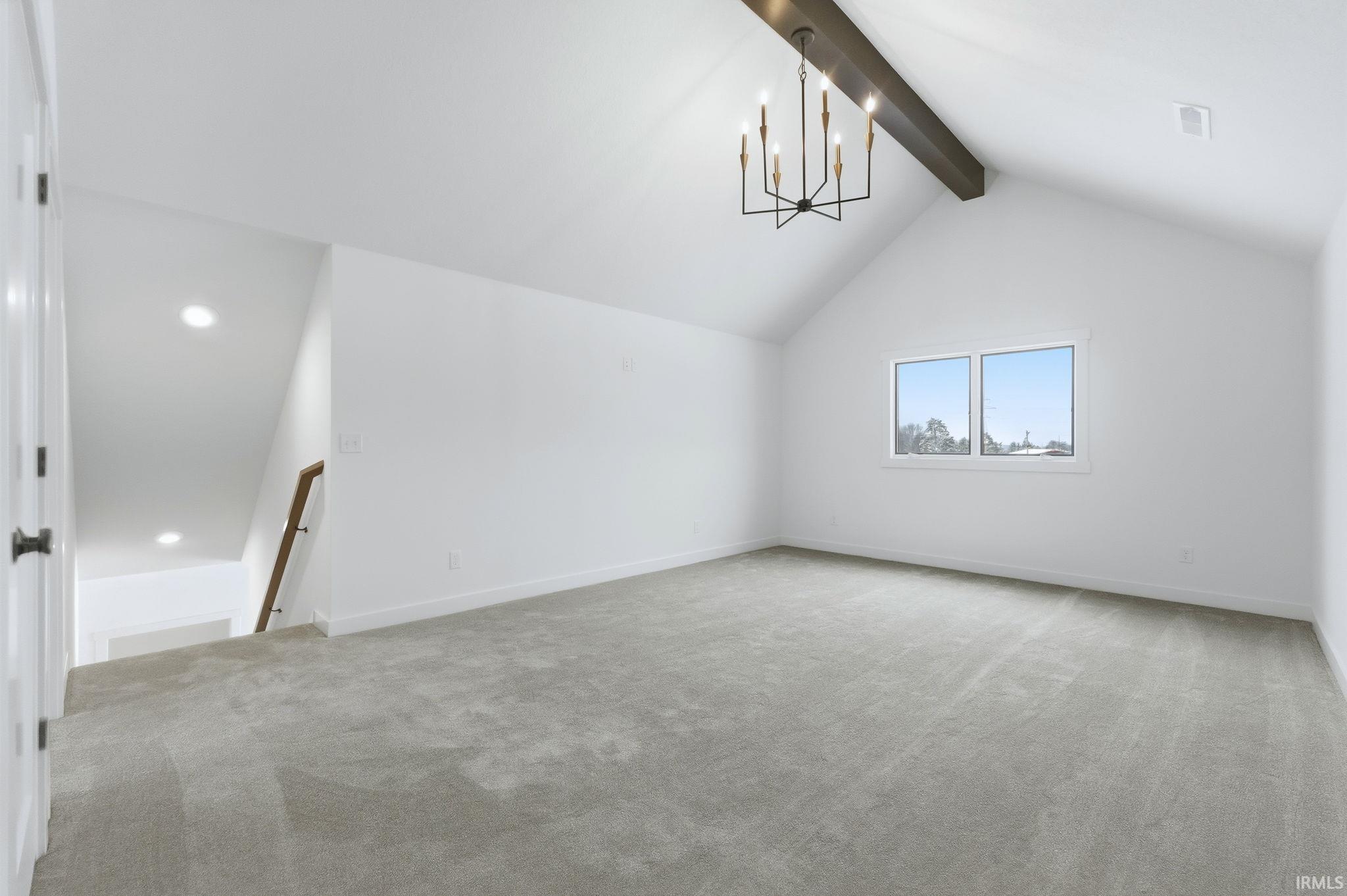 Bonus room with light carpet and a chandelier