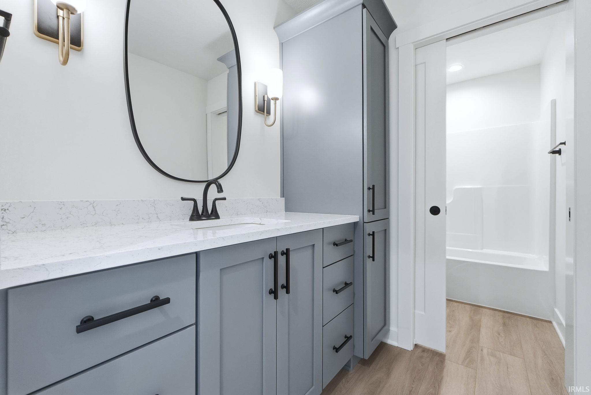 Full bathroom featuring vanity and light wood-type flooring