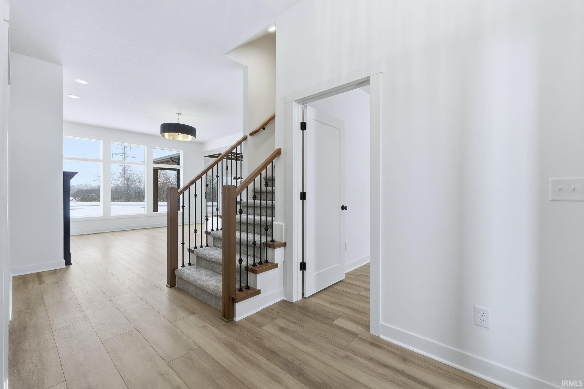 Staircase with wood finished floors and recessed lighting