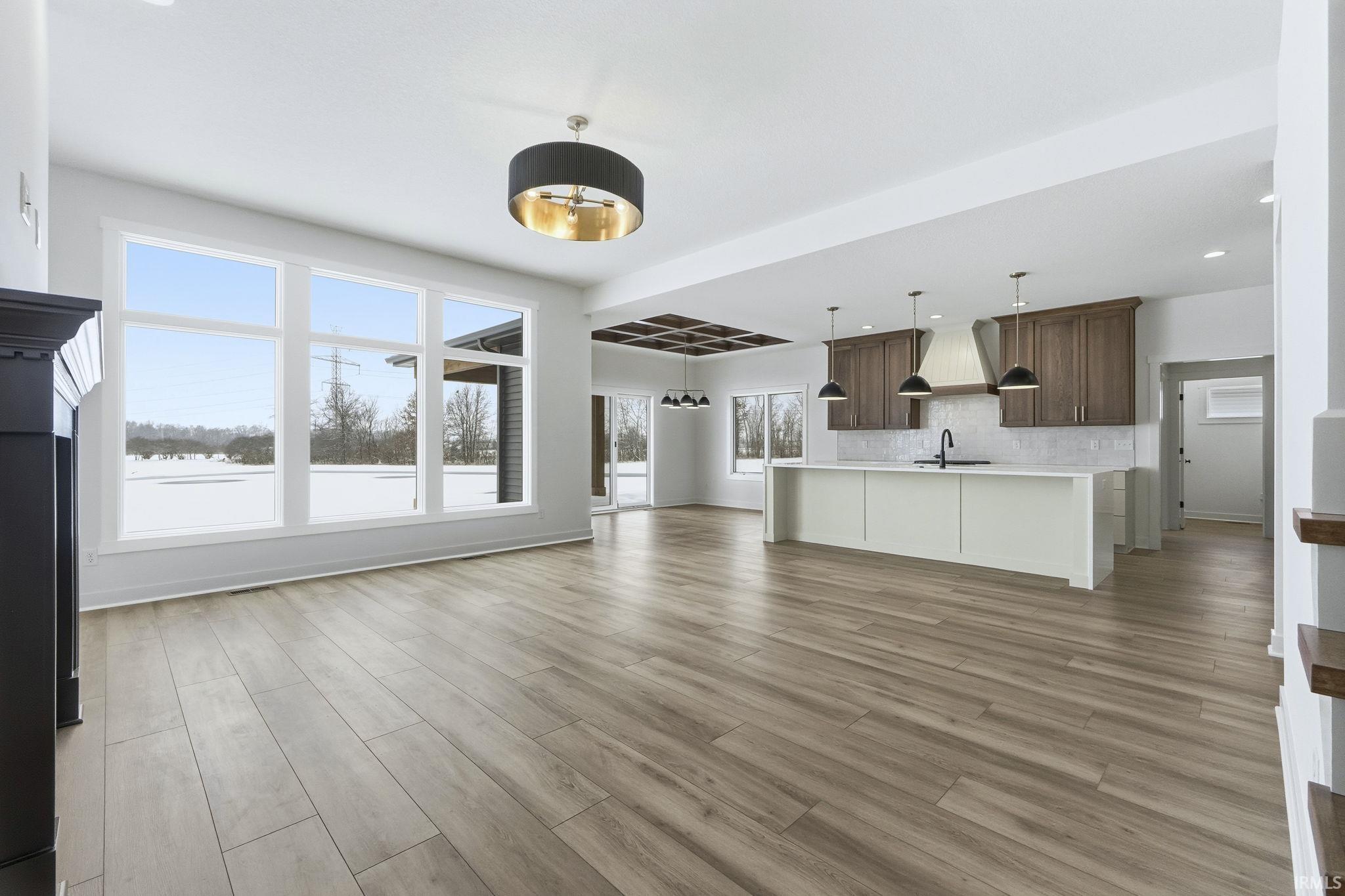 Unfurnished living room with recessed lighting, light wood-style floors, and a chandelier