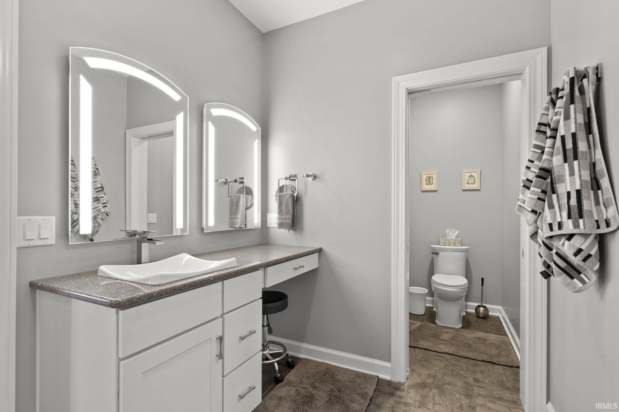 Full bathroom with vanity and baseboards