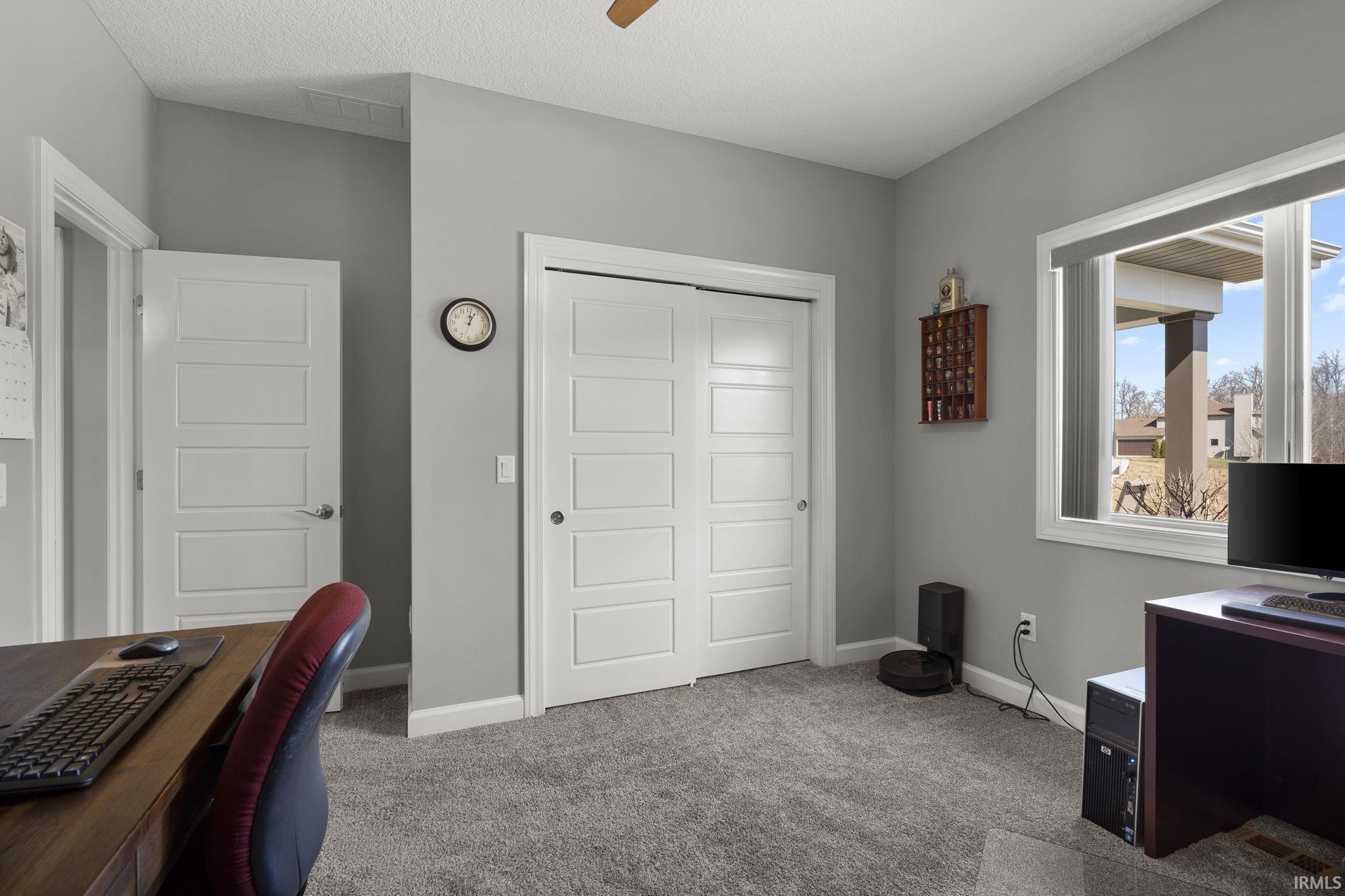 Office featuring light colored carpet, a ceiling fan, and a textured ceiling