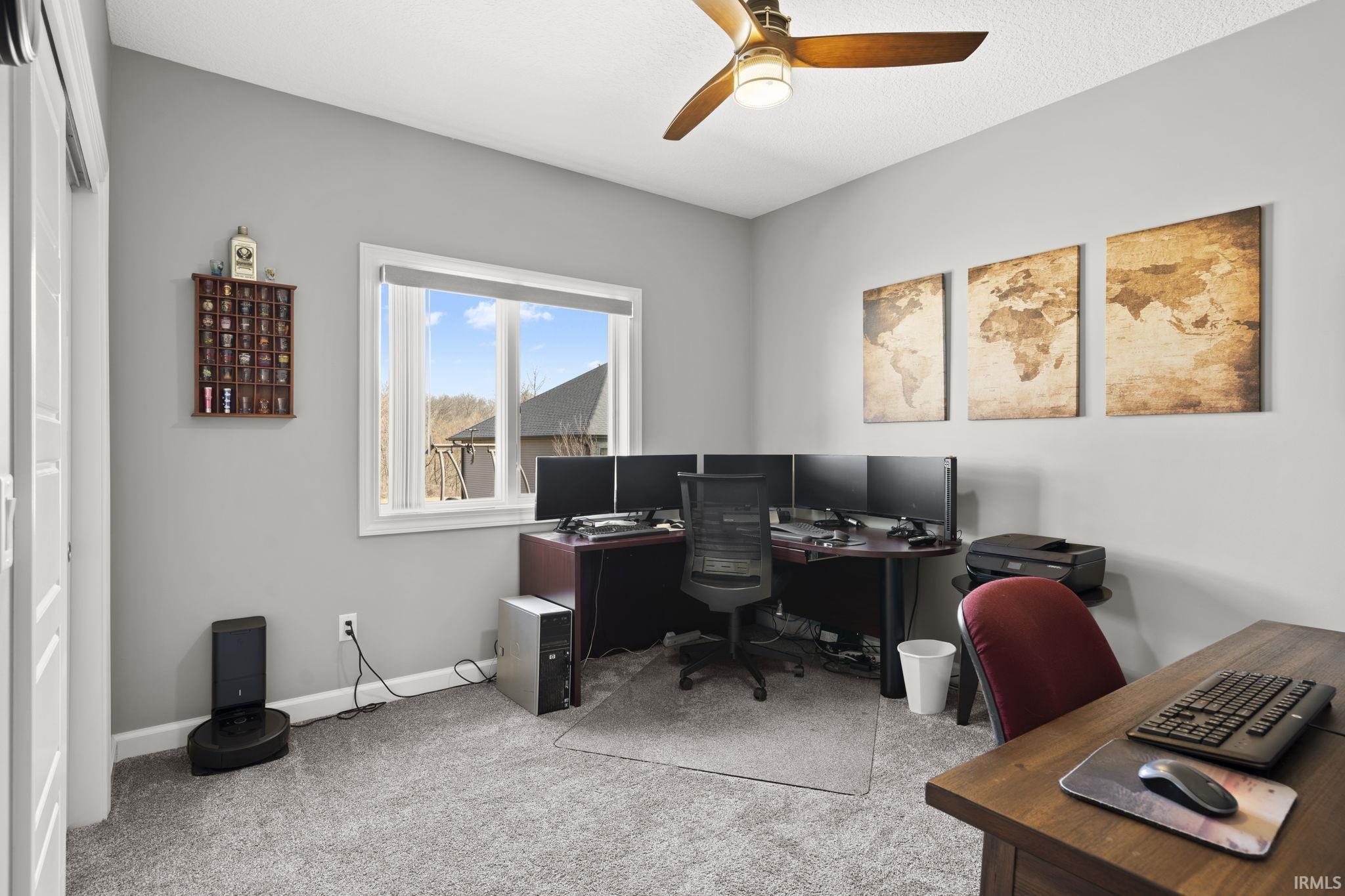 Office area featuring light colored carpet and ceiling fan