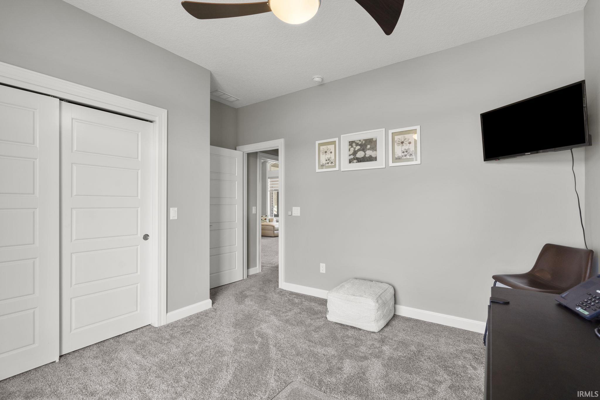 Bedroom featuring light carpet, a closet, and ceiling fan