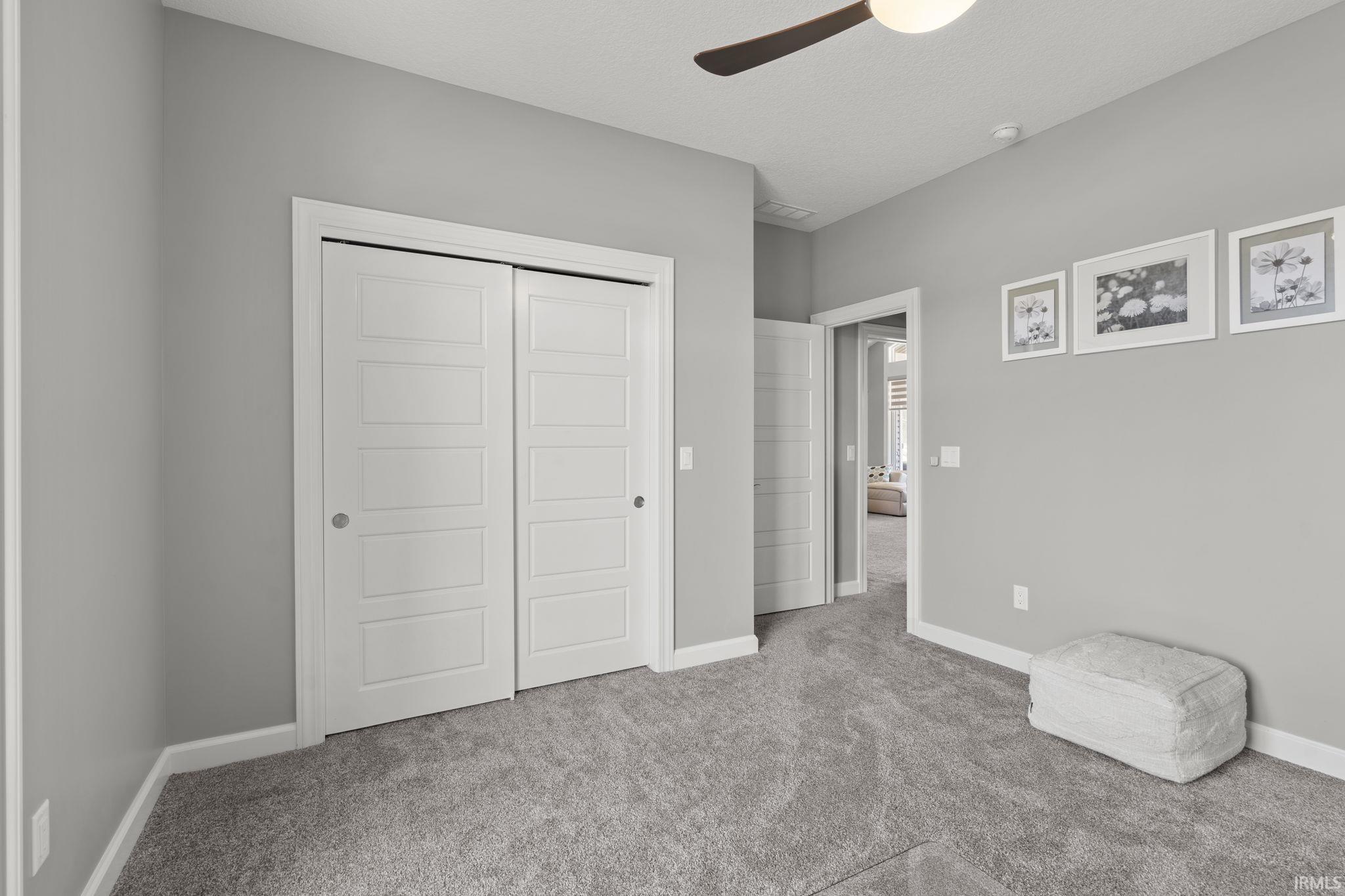 Unfurnished bedroom featuring a closet, carpet flooring, and a ceiling fan