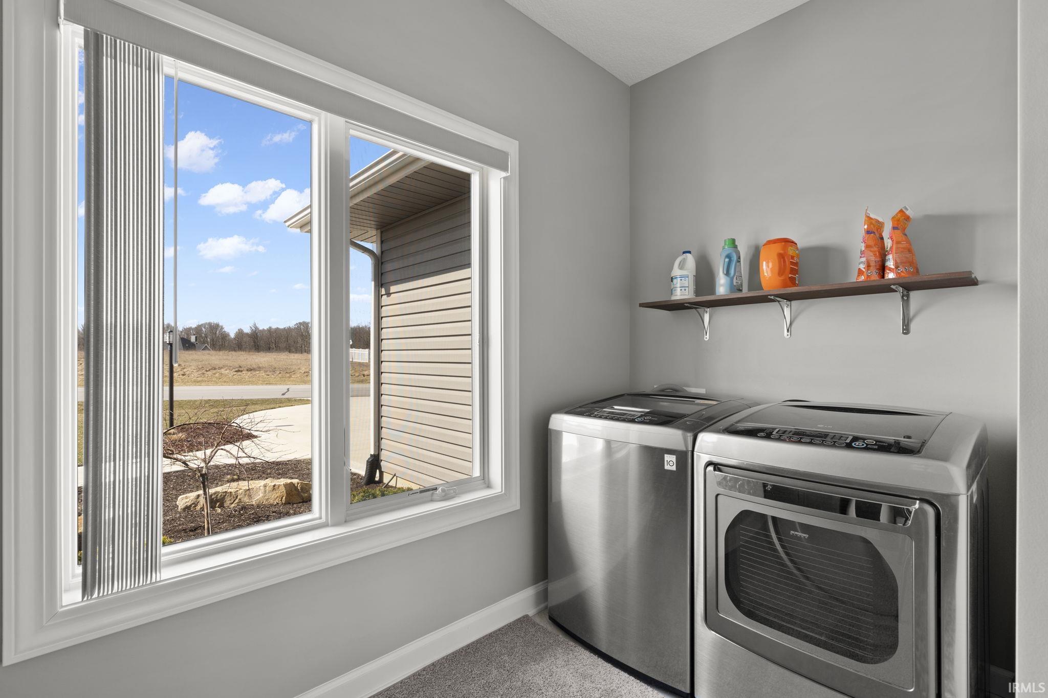 Laundry room featuring washer and clothes dryer and carpet
