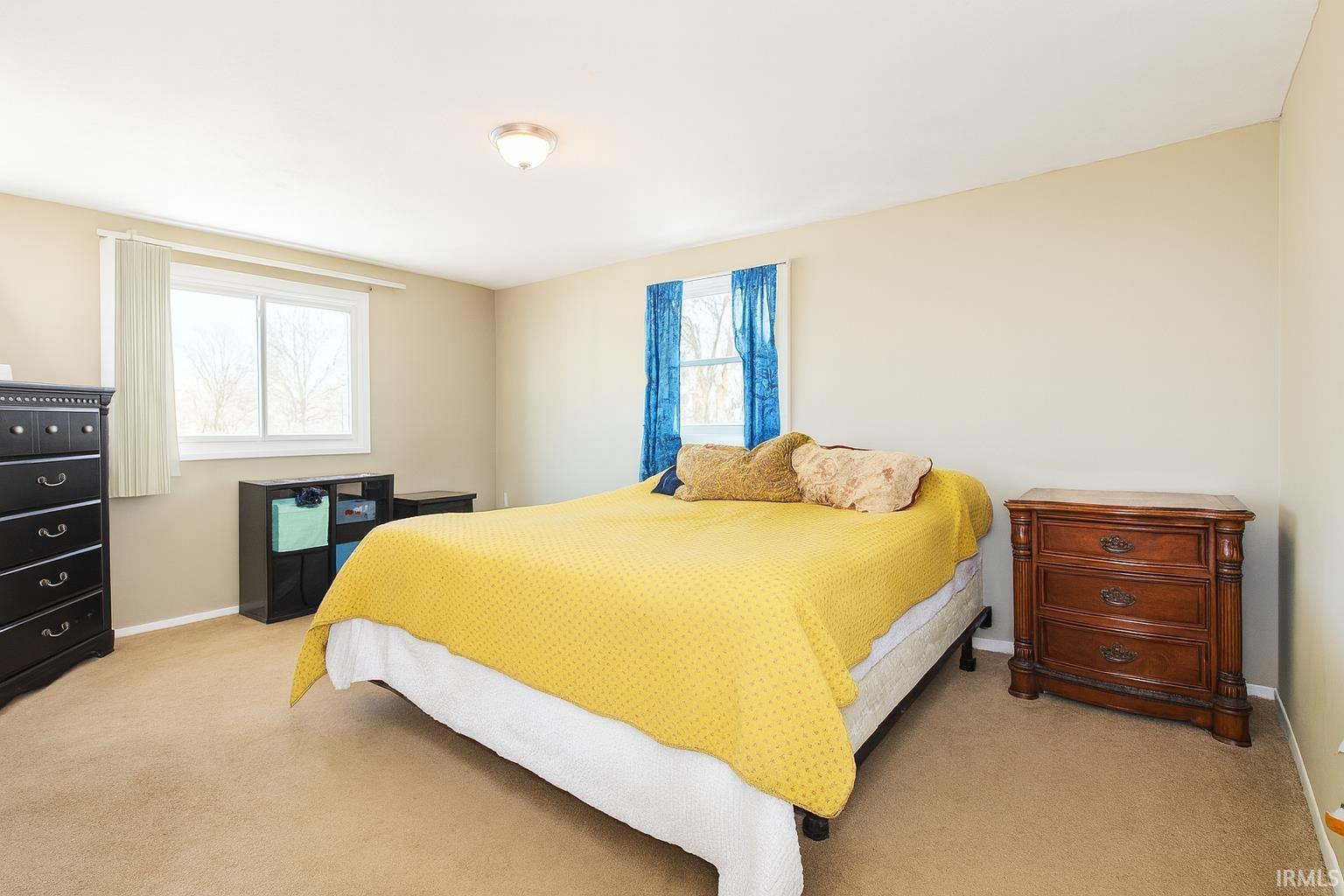 Bedroom featuring light carpet