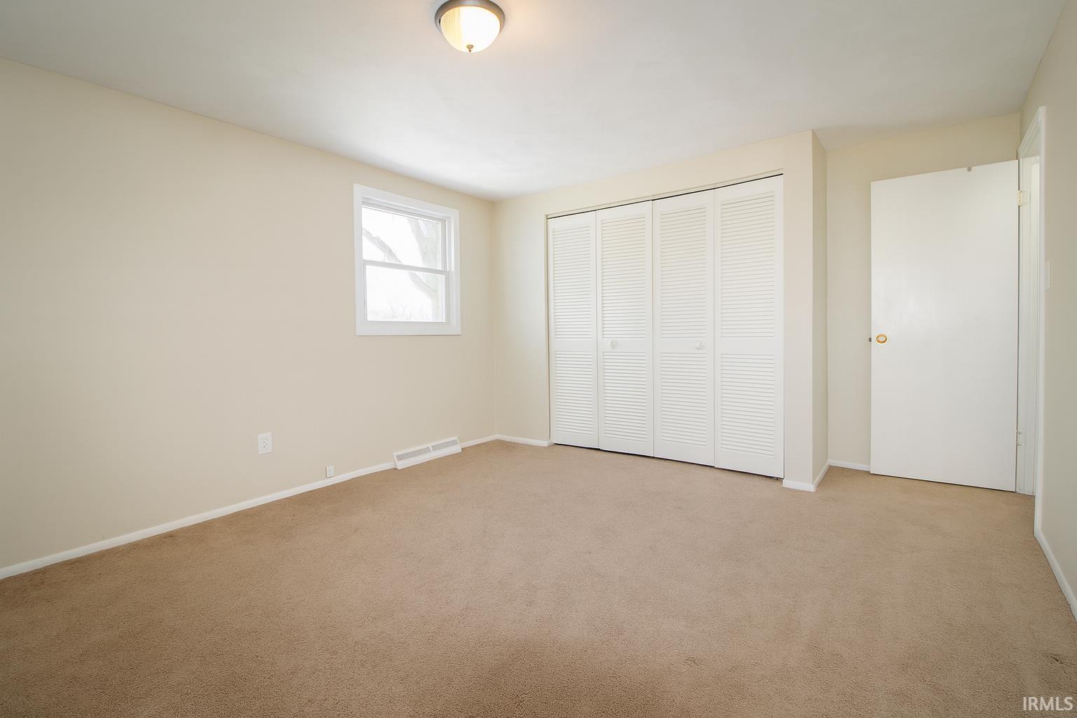Unfurnished bedroom with a closet and carpet