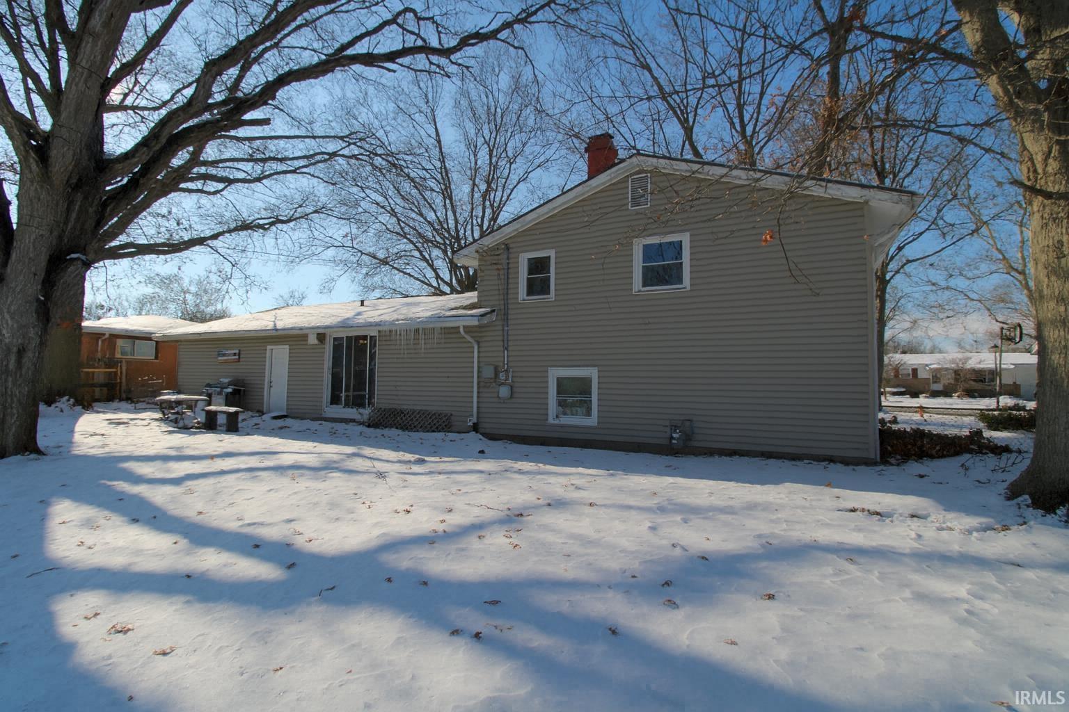 Snow covered house featuring a chimney