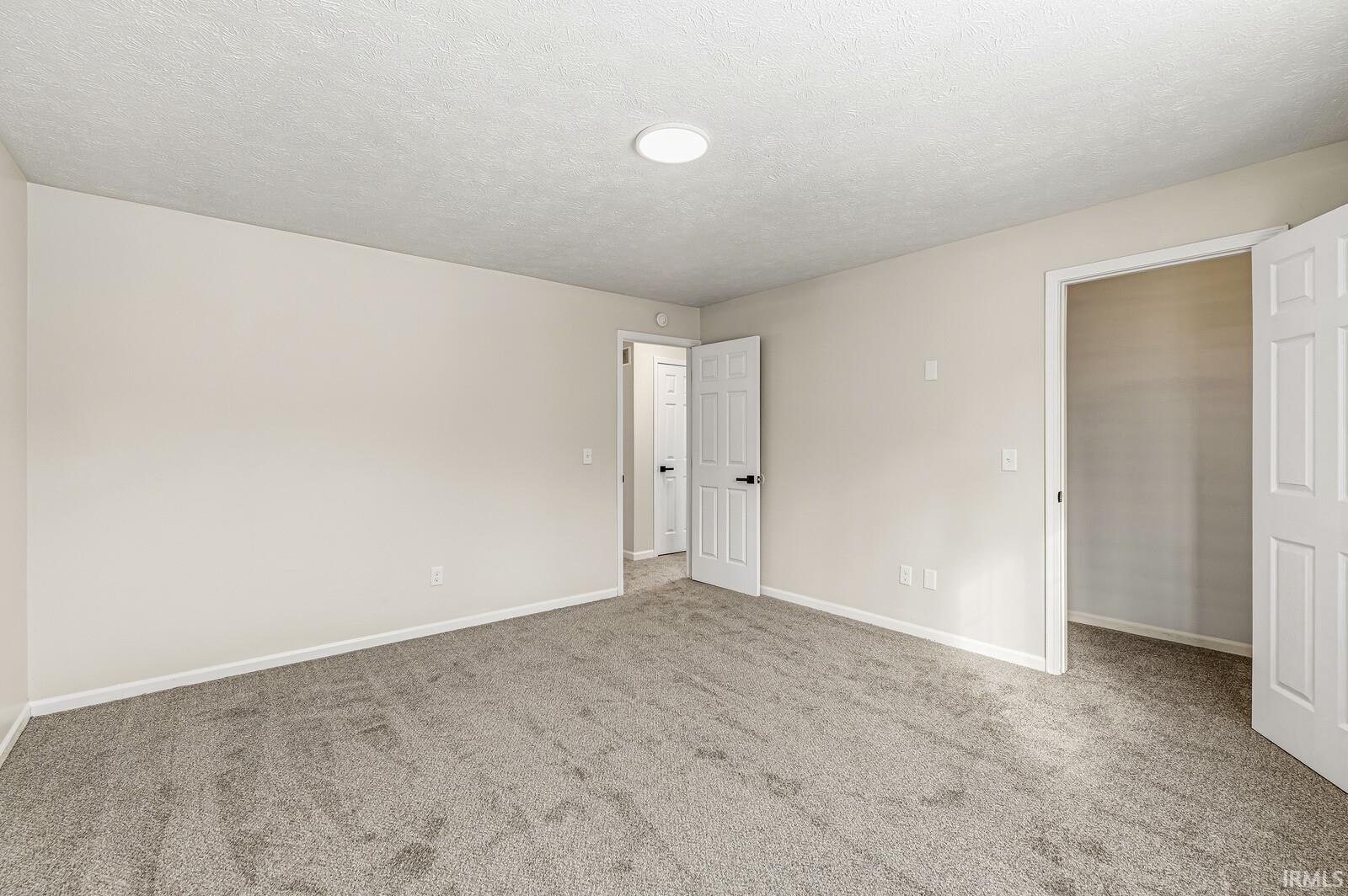 Spare room featuring a textured ceiling and carpet flooring