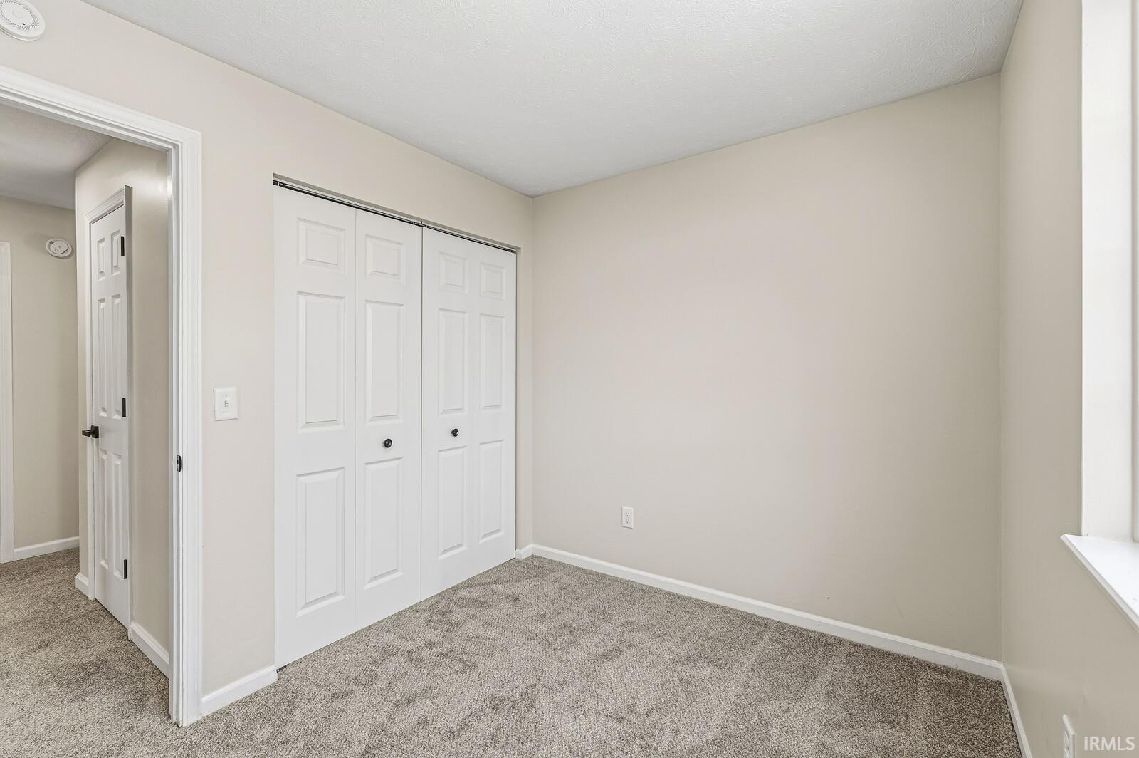Unfurnished bedroom featuring carpet flooring and a closet