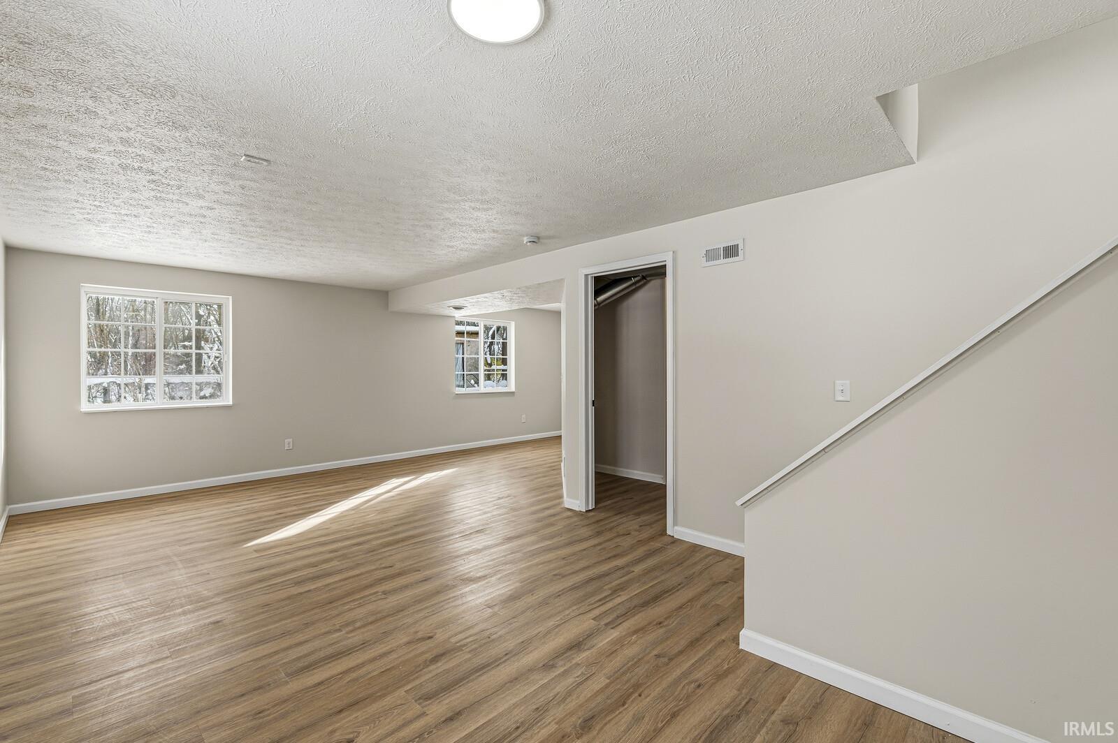 Below grade area featuring wood finished floors and a textured ceiling
