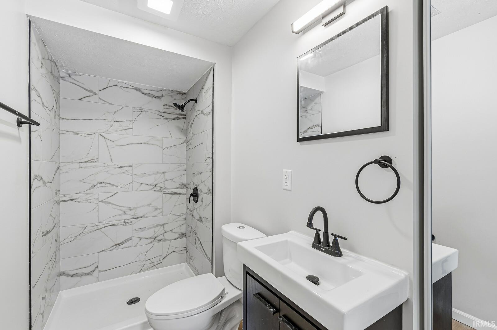 Full bathroom with vanity and a marble finish shower